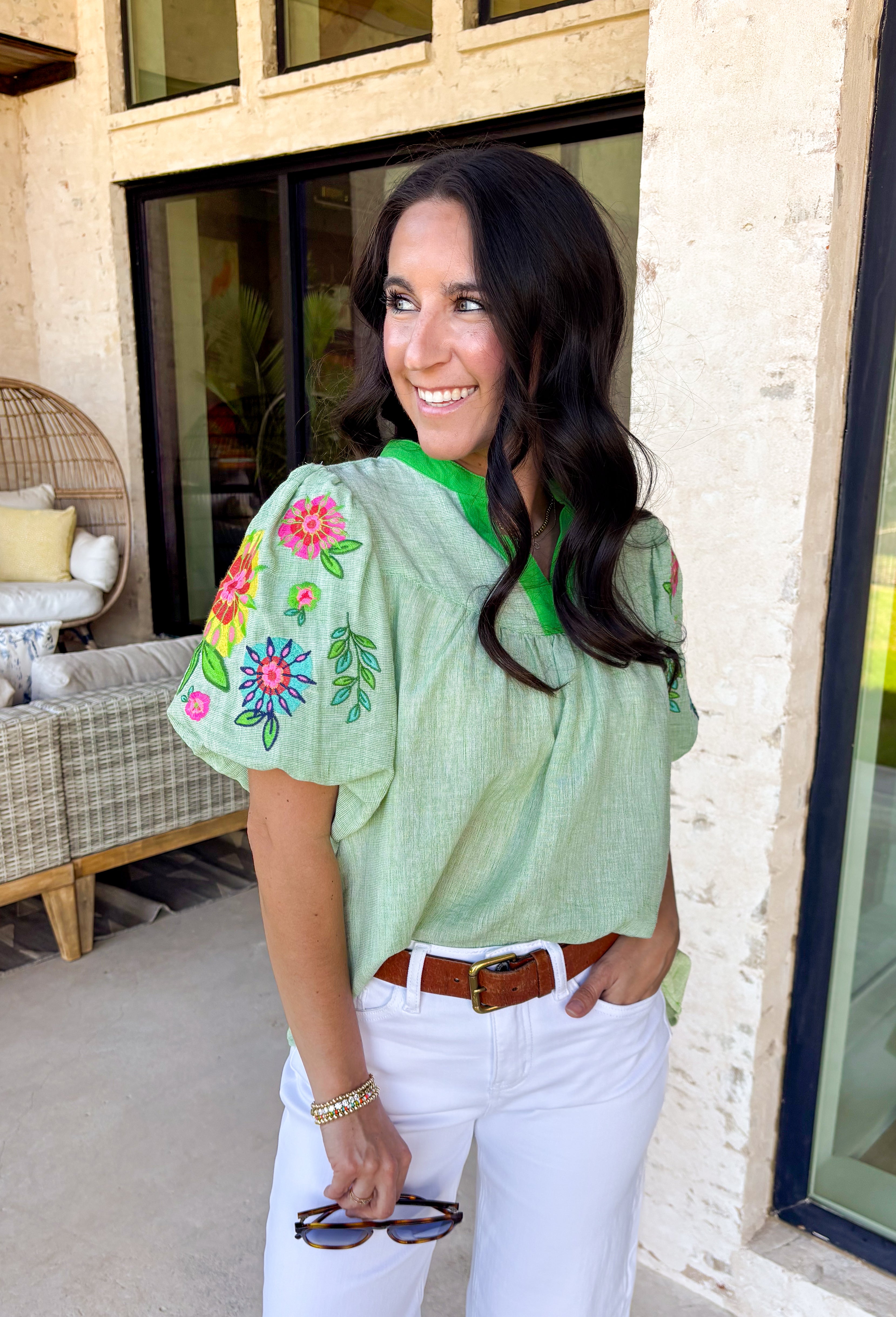This light green short sleeve top is a true spring standout with its cheerful mix of color and texture. The puff sleeves steal the show with vibrant embroidered details in pink, red, blue, yellow, and green, adding a playful, handcrafted feel that instantly elevates your look. A brighter green contrast trim at the neckline gives it a fresh pop that frames the face beautifully. Lightweight and easy to wear, this top is perfect for bringing a little extra color and personality to your everyday spring outfits.