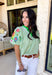 This light green short sleeve top is a true spring standout with its cheerful mix of color and texture. The puff sleeves steal the show with vibrant embroidered details in pink, red, blue, yellow, and green, adding a playful, handcrafted feel that instantly elevates your look. A brighter green contrast trim at the neckline gives it a fresh pop that frames the face beautifully. Lightweight and easy to wear, this top is perfect for bringing a little extra color and personality to your everyday spring outfits.