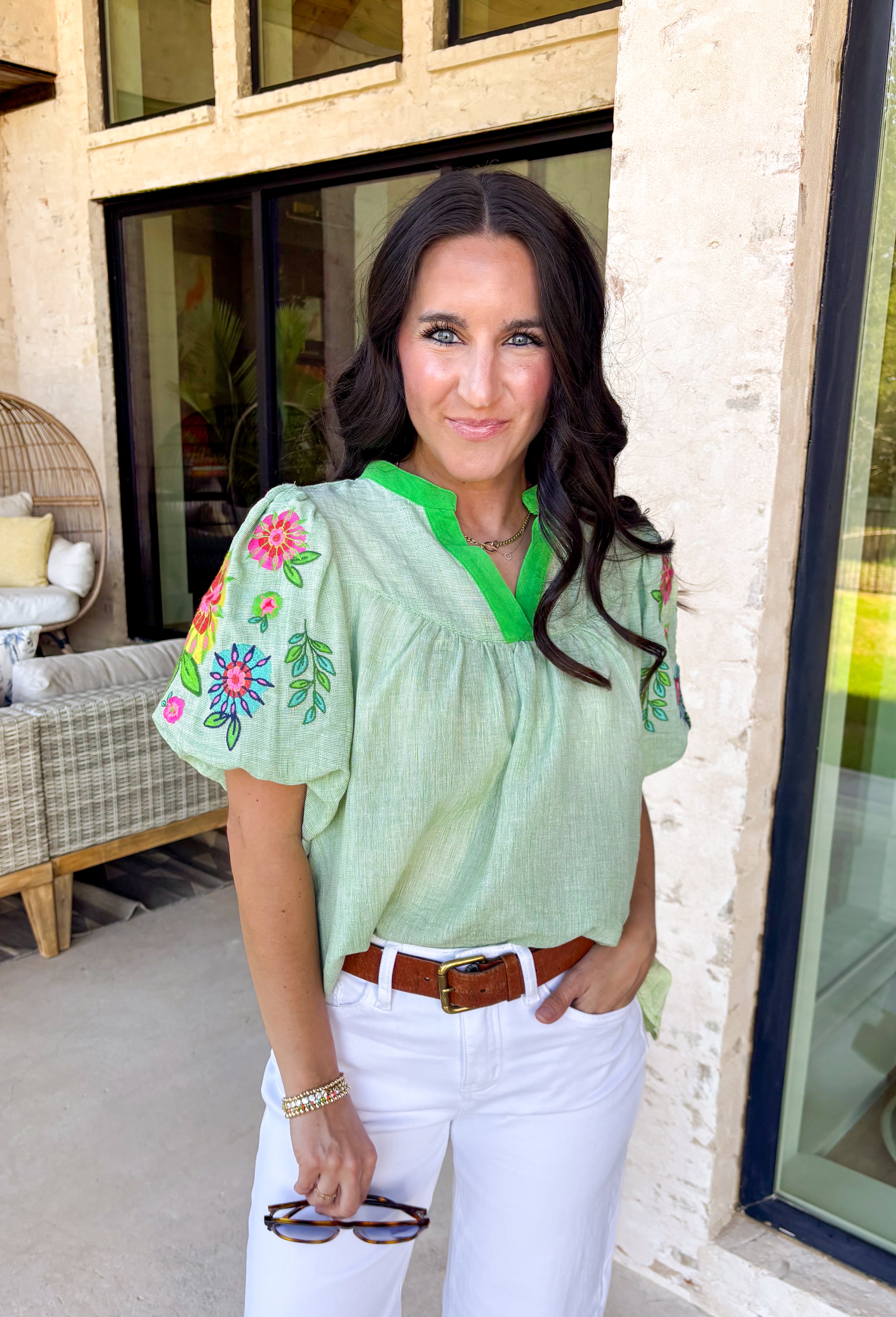 This light green short sleeve top is a true spring standout with its cheerful mix of color and texture. The puff sleeves steal the show with vibrant embroidered details in pink, red, blue, yellow, and green, adding a playful, handcrafted feel that instantly elevates your look. A brighter green contrast trim at the neckline gives it a fresh pop that frames the face beautifully. Lightweight and easy to wear, this top is perfect for bringing a little extra color and personality to your everyday spring outfits.