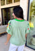 This light green short sleeve top is a true spring standout with its cheerful mix of color and texture. The puff sleeves steal the show with vibrant embroidered details in pink, red, blue, yellow, and green, adding a playful, handcrafted feel that instantly elevates your look. A brighter green contrast trim at the neckline gives it a fresh pop that frames the face beautifully. Lightweight and easy to wear, this top is perfect for bringing a little extra color and personality to your everyday spring outfits.