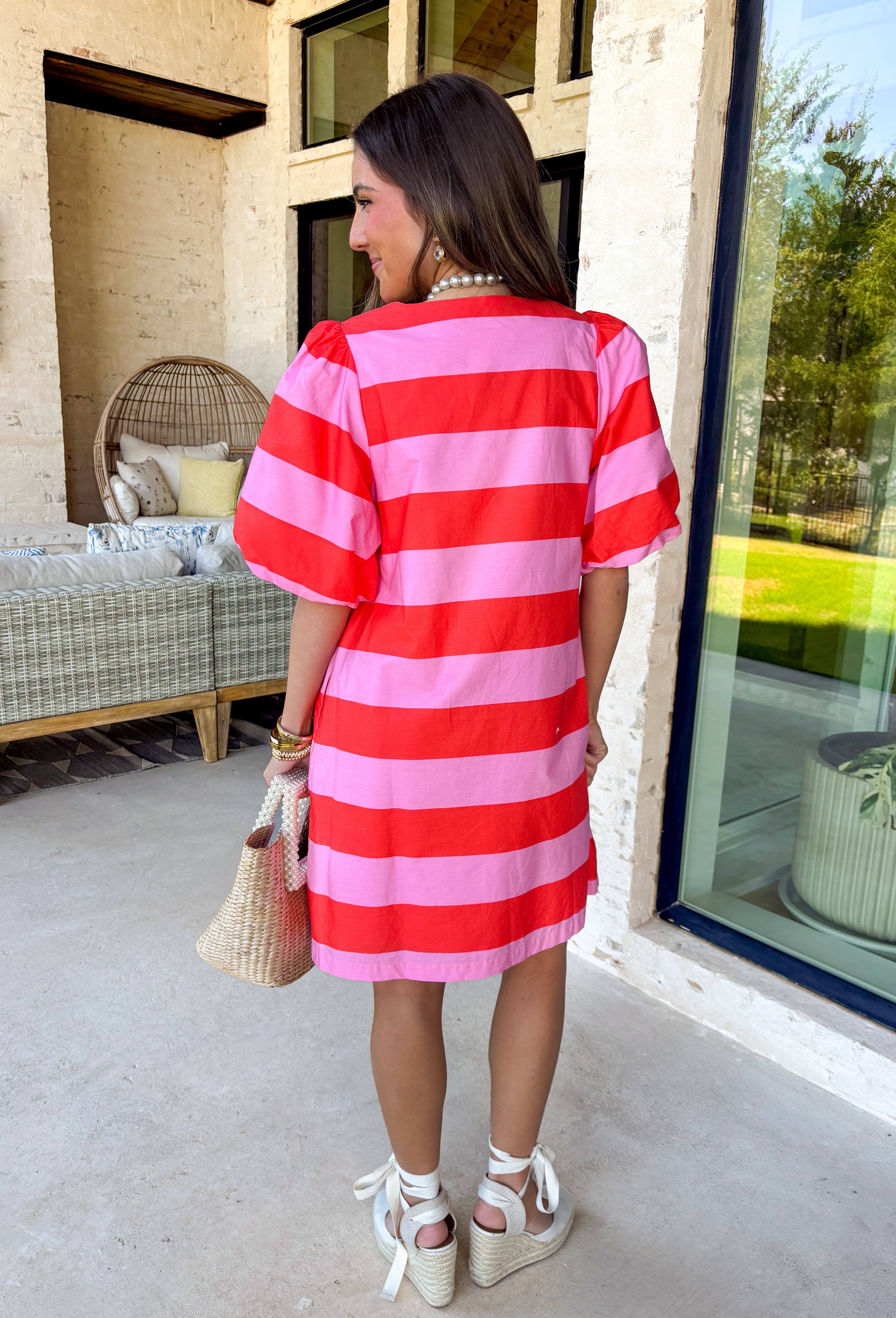 This pink and red striped mini dress by Entro is the definition of fun spring style. The bold stripe print makes a statement all on its own, while the short puff sleeves add that sweet, feminine touch we love. With a button-front design, it feels classic and easy to wear—perfect for those days when you want to look cute without having to think too hard about it.