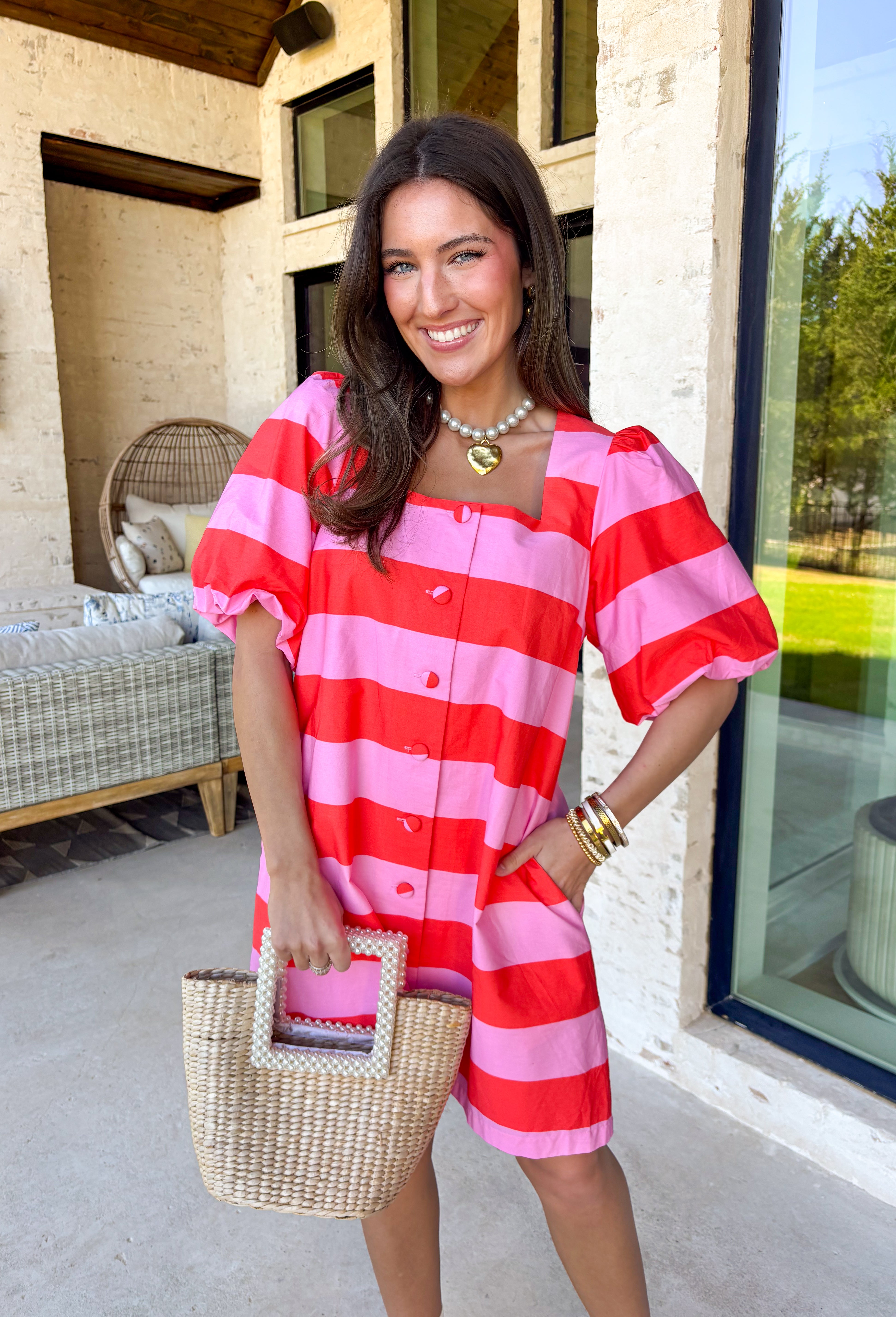 This pink and red striped mini dress by Entro is the definition of fun spring style. The bold stripe print makes a statement all on its own, while the short puff sleeves add that sweet, feminine touch we love. With a button-front design, it feels classic and easy to wear—perfect for those days when you want to look cute without having to think too hard about it.