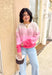 colorblocked pink sweater with different shades of pink and oatmeal styled with a trucker hat and wide leg jeans