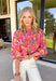 This pink long sleeve top is giving fresh-picked flower energy in the prettiest way. Featuring a colorful floral print in shades of green, yellow, orange, and white, it’s the kind of piece that instantly brightens your day (and your outfit). The pink base keeps it sweet, while the vibrant florals make it feel playful and ready for sunshine. Designed with front button details and elastic cuff sleeves, this top blends classic structure with easy comfort. 