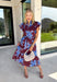 Embrace the beauty of the season in this stunning wine floral midi dress. Featuring a gorgeous blue and white floral print, this feminine dress is perfect for everything on your fall calendar. The self-tie belt cinches the waist for a flattering silhouette, while the ruffle sleeves and ruffle hem add soft movement and romantic charm. Finished with a button-down front, side pockets, and a fully lined design, this timeless cotton dress.