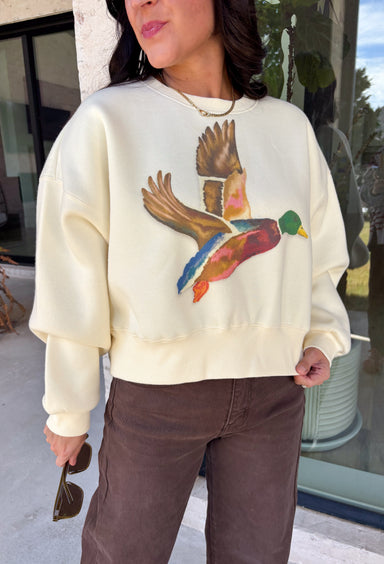 Stay cozy while showing off your love for the outdoors with this fun graphic sweatshirt from Poppy &amp; Pine. Designed in a classic white hue, this fleece-lined pullover features a charming mallard duck graphic across the front for the perfect blend of playful style and everyday comfort. The ultra-soft interior keeps you warm on crisp fall days, while the ribbed neckline, cuffs, and hem create a timeless fit you'll love.