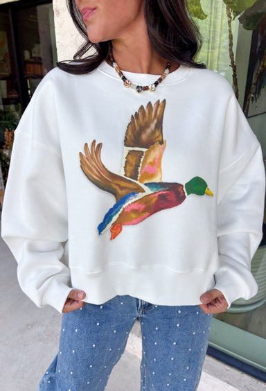 Stay cozy while showing off your love for the outdoors with this fun graphic sweatshirt from Poppy &amp; Pine. Designed in a classic white hue, this fleece-lined pullover features a charming mallard duck graphic across the front for the perfect blend of playful style and everyday comfort. The ultra-soft interior keeps you warm on crisp fall days, while the ribbed neckline, cuffs, and hem create a timeless fit you'll love. 