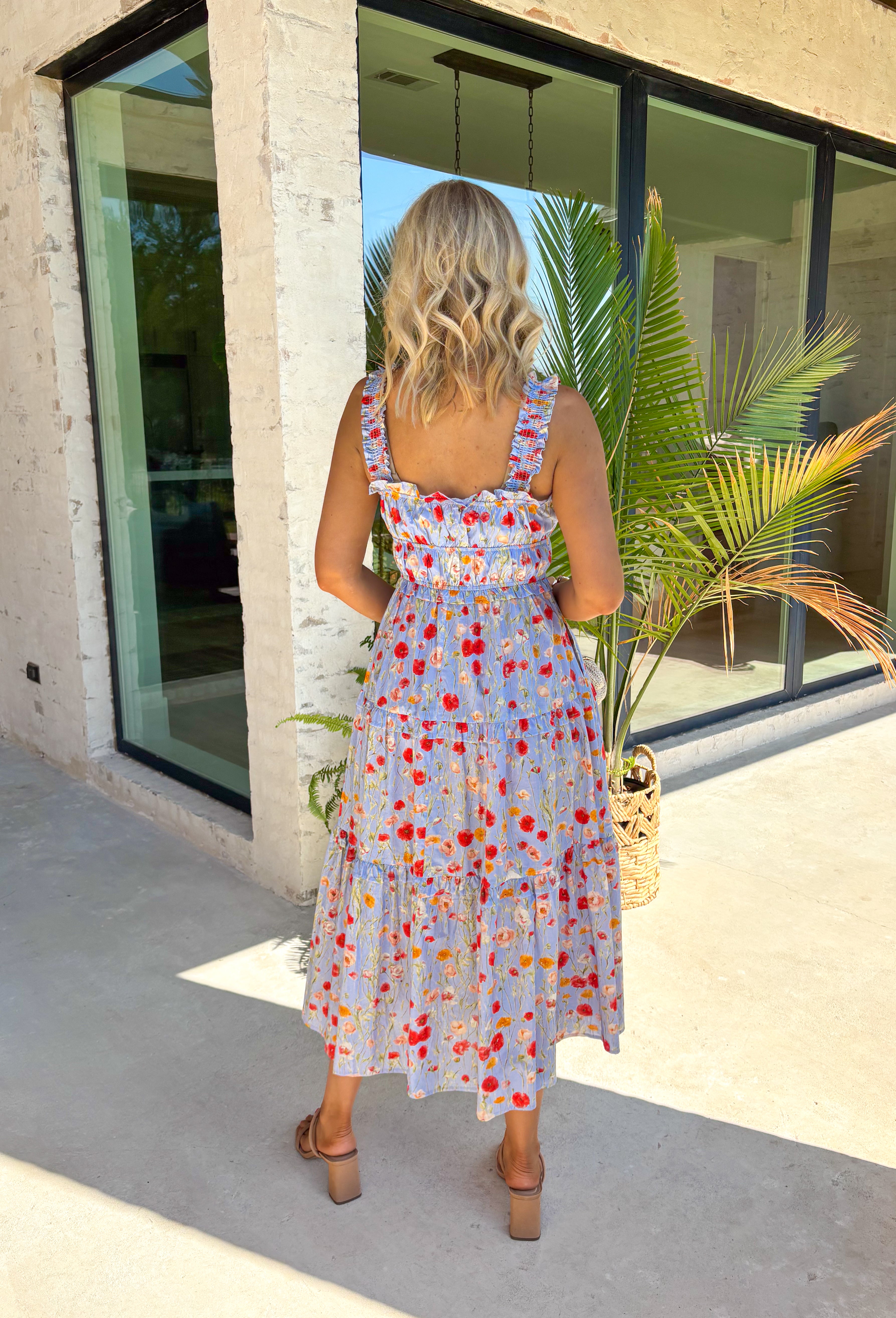 This sleeveless light blue midi dress by Entro is giving major spring picnic energy. With a colorful floral print in pops of red, mustard, and light pink, it’s bright, cheerful, and made for sunny days. The blue and white gingham trim along the top adds the cutest contrast, and the three front tie details bring in that extra sweet, feminine touch we can’t get enough of. 