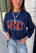 Bring a little extra luck to your cozy season with this playful graphic sweatshirt. Featuring "Lucky" in rust lettering accented with whimsical stars and outlined by a light blue circle, this navy pullover adds the perfect pop of color to your everyday wardrobe. The fleece-lined interior keeps you warm and comfortable, making it the perfect choice for football weekends, coffee runs, casual days, and cozy nights in. It's an easy favorite you'll be reaching for all fall and winter long.