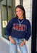 Bring a little extra luck to your cozy season with this playful graphic sweatshirt. Featuring "Lucky" in rust lettering accented with whimsical stars and outlined by a light blue circle, this navy pullover adds the perfect pop of color to your everyday wardrobe. The fleece-lined interior keeps you warm and comfortable, making it the perfect choice for football weekends, coffee runs, casual days, and cozy nights in. It's an easy favorite you'll be reaching for all fall and winter long.