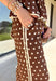Make a statement from the bottom up with these brown and cream polka dot pants from Entro. The warm brown background paired with classic cream polka dots gives them a playful look that still works beautifully with your favorite fall neutrals. An elasticated waist with a self-tie keeps the fit comfortable and adjustable, while contrast trim along the sides adds an unexpected finishing touch. 