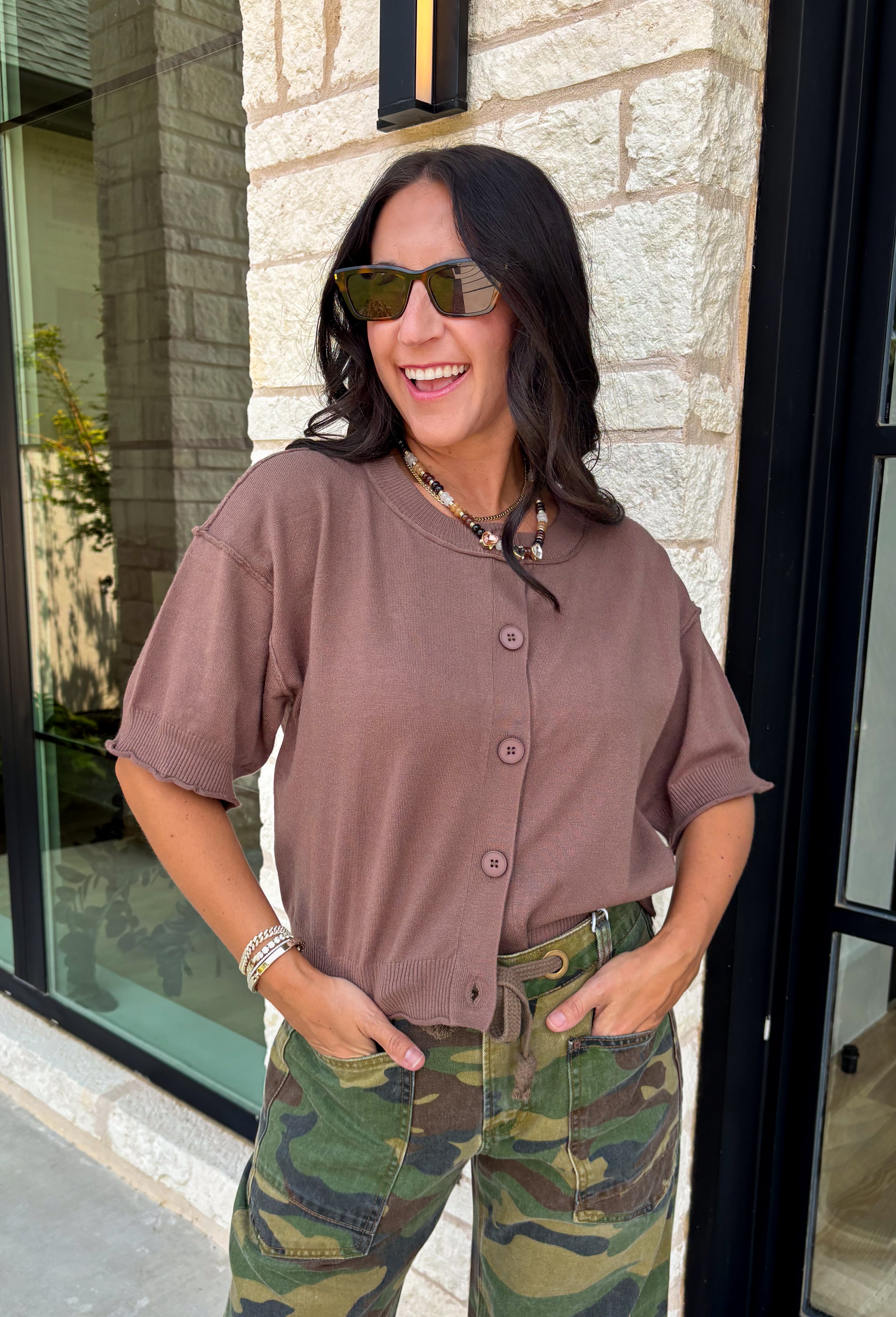 The perfect layering piece has arrived just in time for sweater weather. This chocolate brown cardigan is crafted from a soft sweater knit that makes every outfit feel a little cozier while still looking effortlessly polished. The button-front design gives you endless styling options—wear it buttoned as a top or layered over your favorite tanks and dresses. Finished with exposed hems and classic ribbed trim, this versatile cardigan is one you'll reach for from crisp fall mornings through the holiday season.
