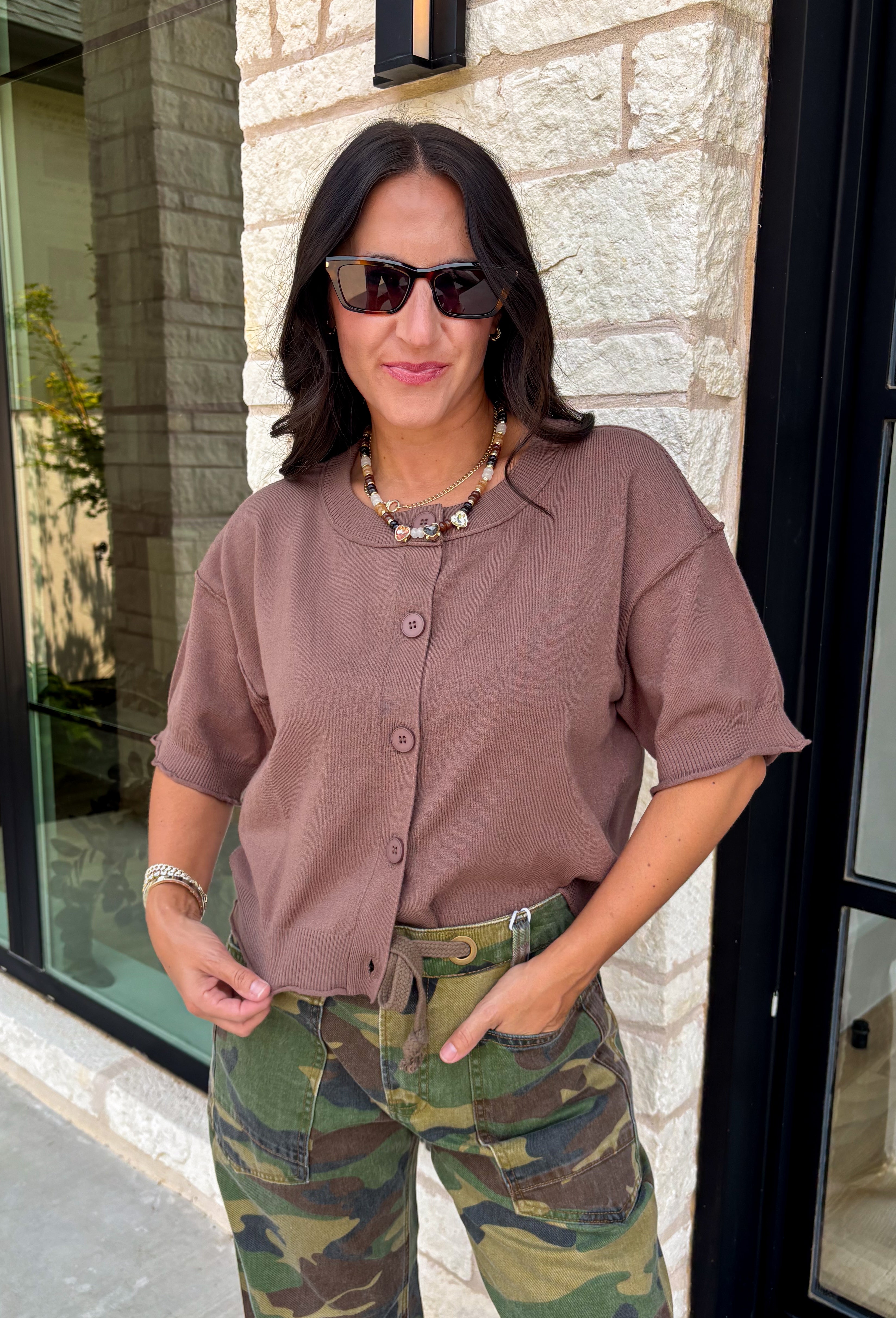 The perfect layering piece has arrived just in time for sweater weather. This chocolate brown cardigan is crafted from a soft sweater knit that makes every outfit feel a little cozier while still looking effortlessly polished. The button-front design gives you endless styling options—wear it buttoned as a top or layered over your favorite tanks and dresses. Finished with exposed hems and classic ribbed trim, this versatile cardigan is one you'll reach for from crisp fall mornings through the holiday season.