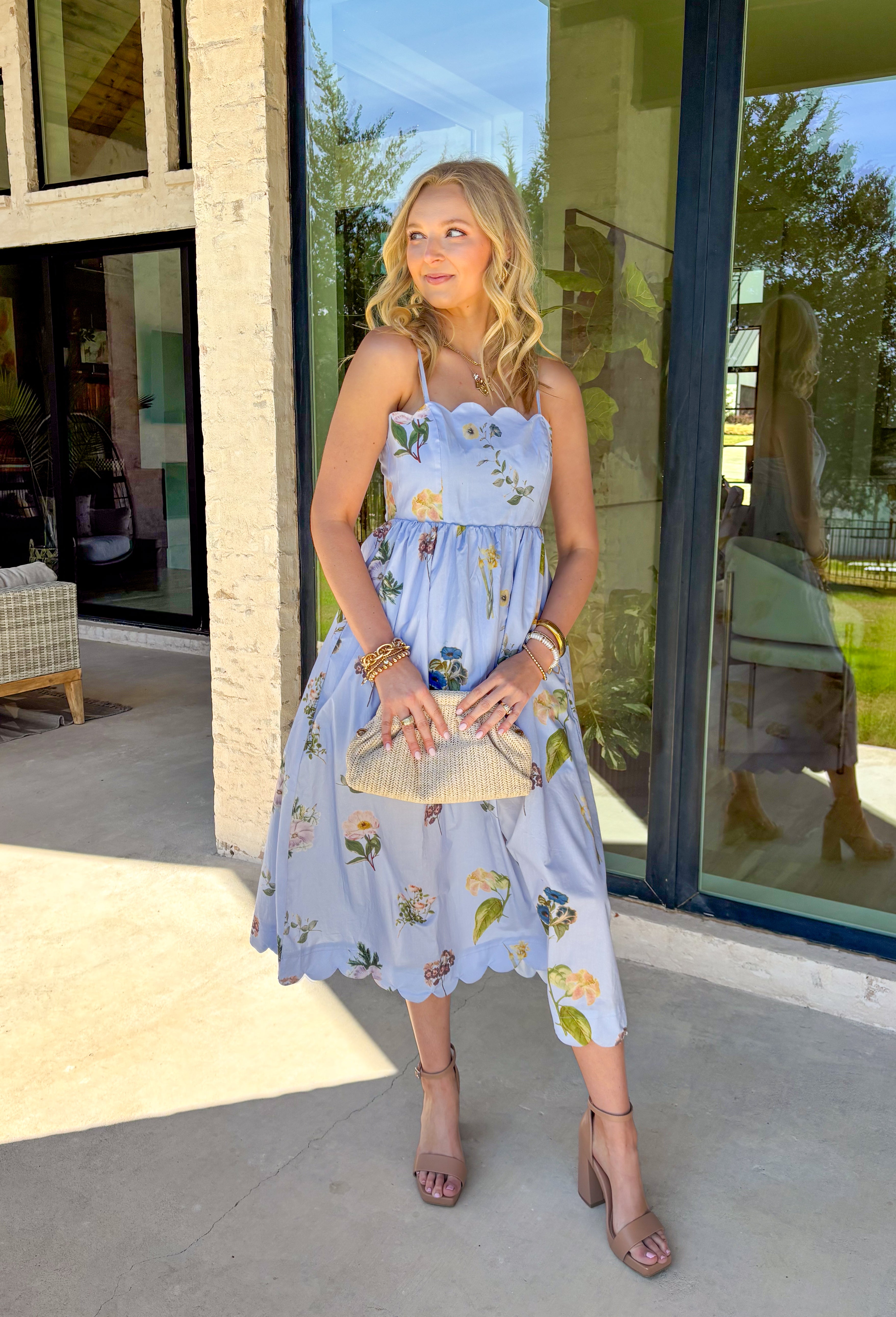 This light blue sleeveless dress is pure springtime sweetness! With a floral print sprinkled throughout, it feels fresh, feminine, and perfect for sunny days ahead. The scalloped neckline and matching scalloped hem add the prettiest little detail that makes this dress feel extra special. The adjustable straps let you customize the fit, and the elastic back with a self-tie detail keeps it comfy while giving you a flattering shape. Fully lined for coverage and finished with side pockets.