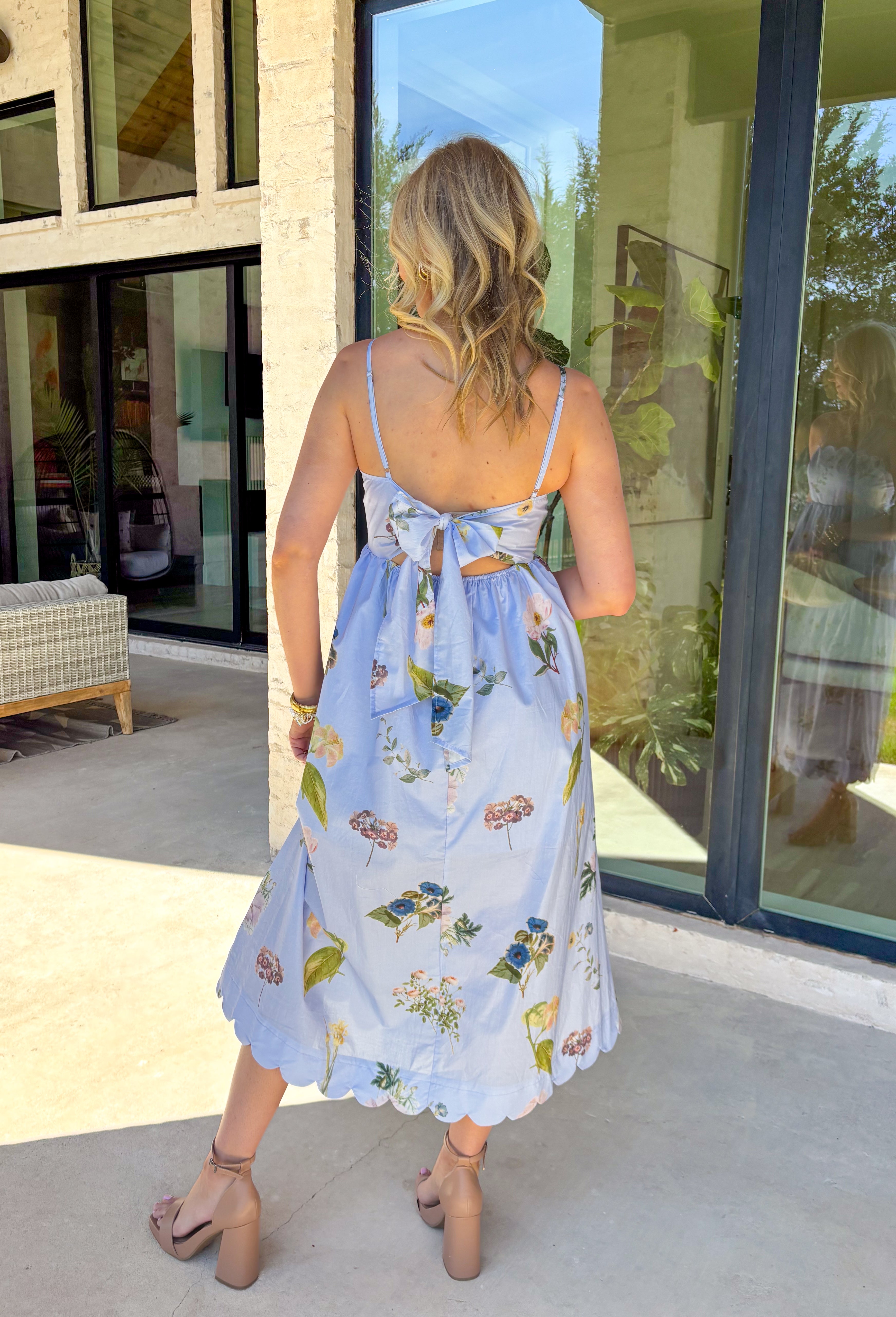 This light blue sleeveless dress is pure springtime sweetness! With a floral print sprinkled throughout, it feels fresh, feminine, and perfect for sunny days ahead. The scalloped neckline and matching scalloped hem add the prettiest little detail that makes this dress feel extra special. The adjustable straps let you customize the fit, and the elastic back with a self-tie detail keeps it comfy while giving you a flattering shape. Fully lined for coverage and finished with side pockets.