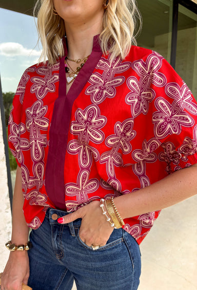 Warm autumn tones and effortless style come together in this beautiful abstract print top. Designed in a rich brick hue with an eye-catching abstract pattern, this lightweight cotton blouse is the perfect blend of classic and contemporary. The contrast neckline adds a polished touch to the flattering v-neckline, while the puff sleeves with elastic cuffs create a feminine silhouette that's easy to dress up or down. 