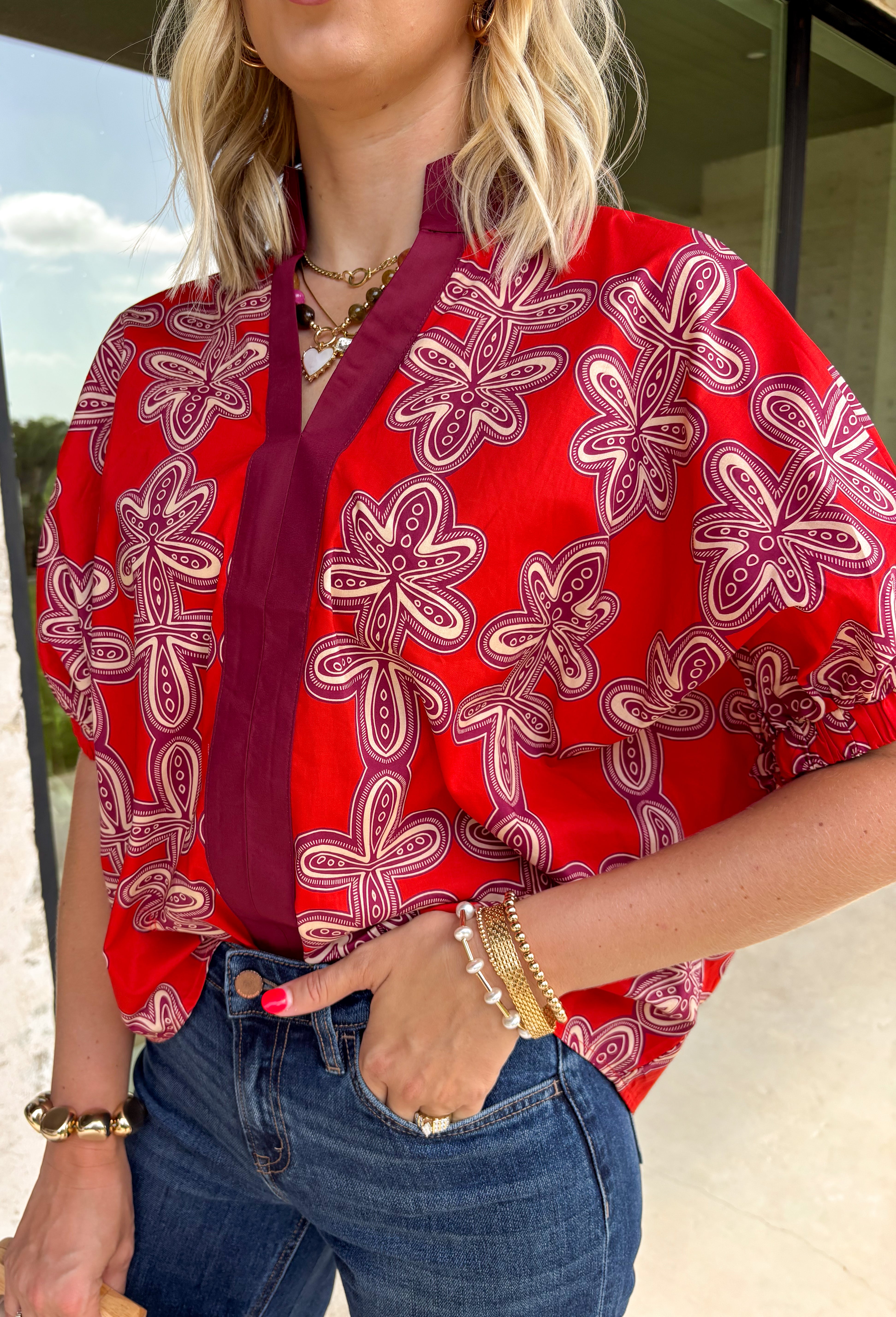 Warm autumn tones and effortless style come together in this beautiful abstract print top. Designed in a rich brick hue with an eye-catching abstract pattern, this lightweight cotton blouse is the perfect blend of classic and contemporary. The contrast neckline adds a polished touch to the flattering v-neckline, while the puff sleeves with elastic cuffs create a feminine silhouette that's easy to dress up or down. 