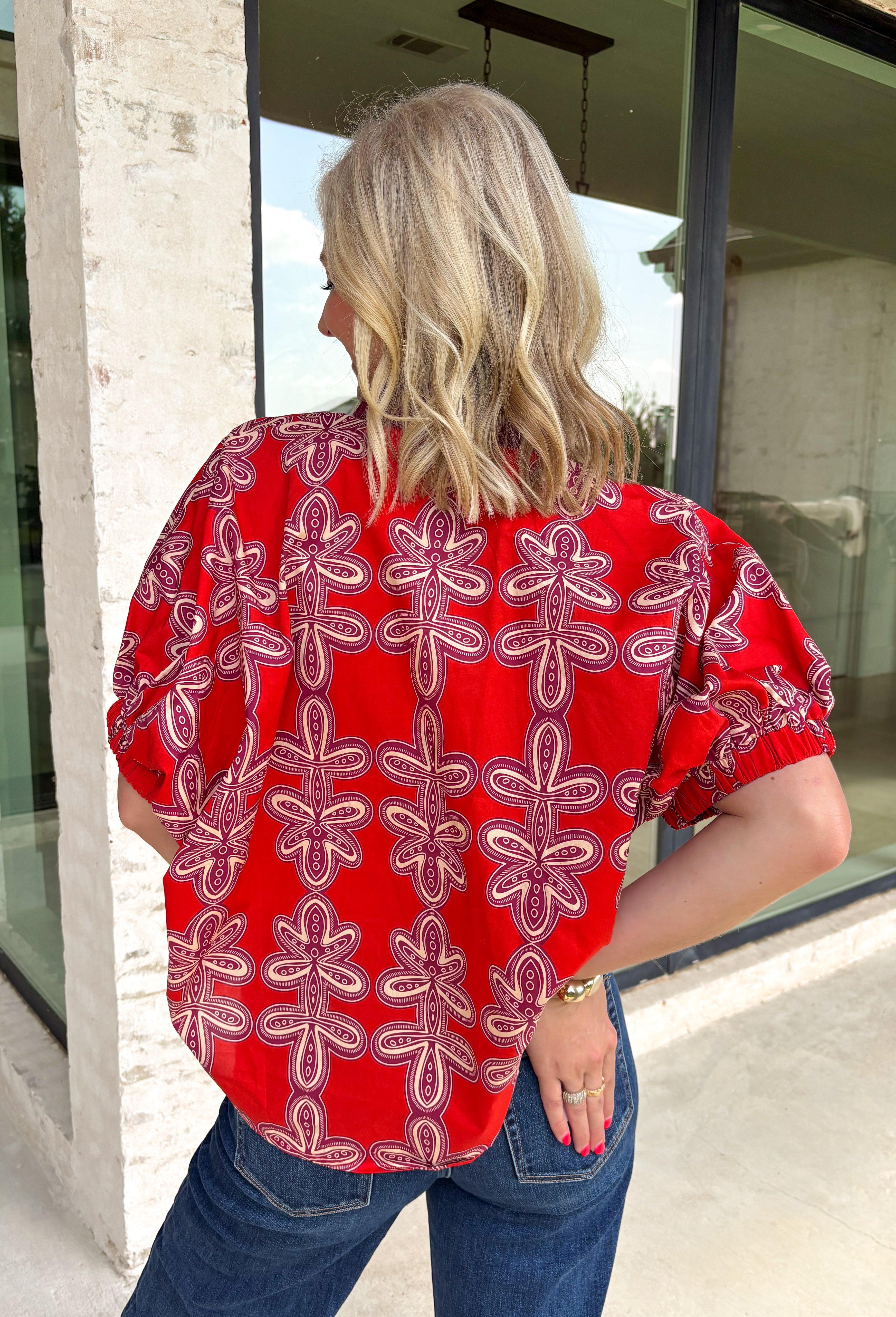 Warm autumn tones and effortless style come together in this beautiful abstract print top. Designed in a rich brick hue with an eye-catching abstract pattern, this lightweight cotton blouse is the perfect blend of classic and contemporary. The contrast neckline adds a polished touch to the flattering v-neckline, while the puff sleeves with elastic cuffs create a feminine silhouette that's easy to dress up or down. 