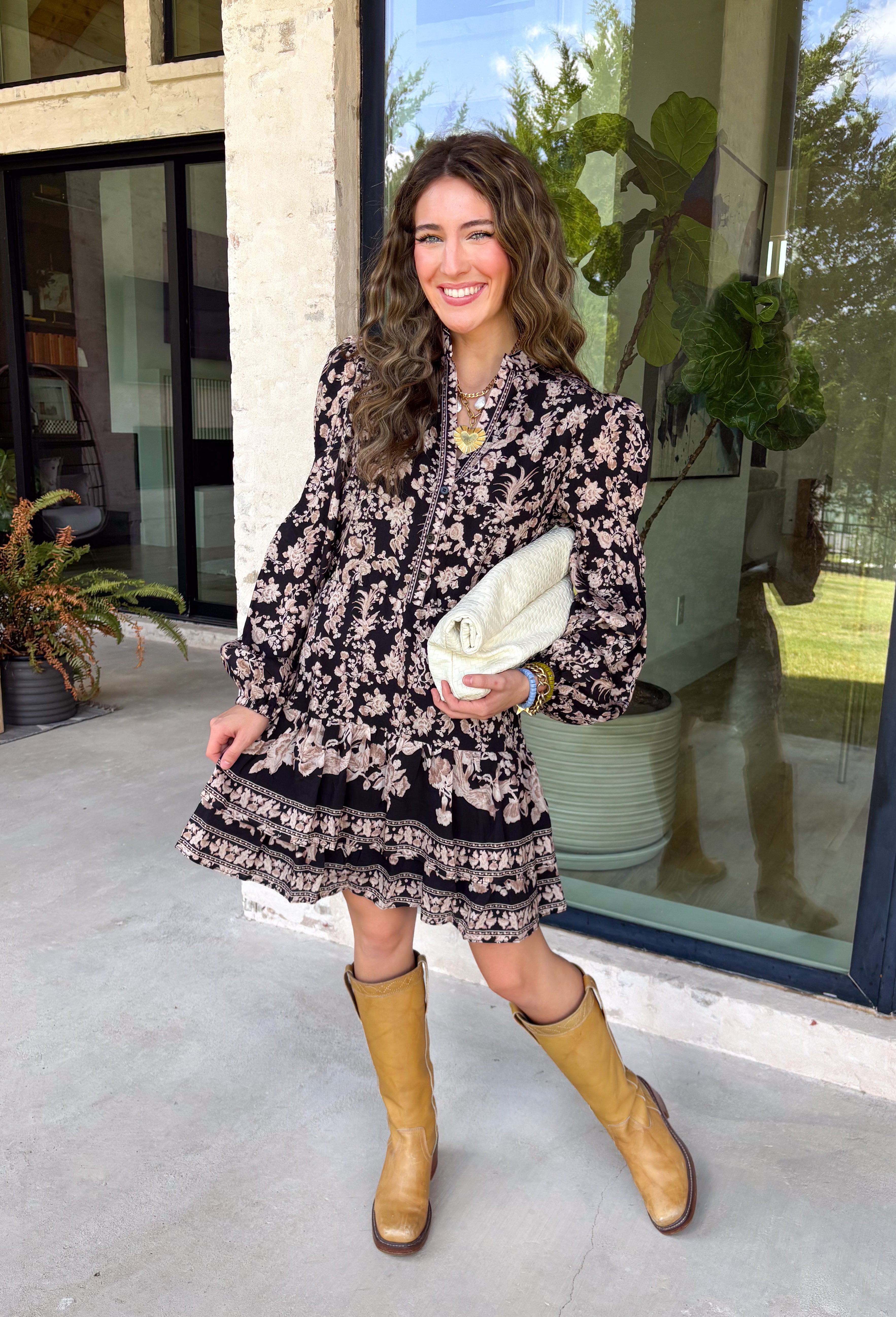 Chic, timeless, and effortlessly feminine, this floral dress is made for every special moment on your fall calendar. Featuring a classic black backdrop with a beautiful tan and off-white floral print, this dress offers a sophisticated look that's easy to wear from day to night. The button-front bodice, long sleeves, and tiered skirt create a flattering silhouette with graceful movement, while the elastic cuffs add a comfortable finishing touch. 