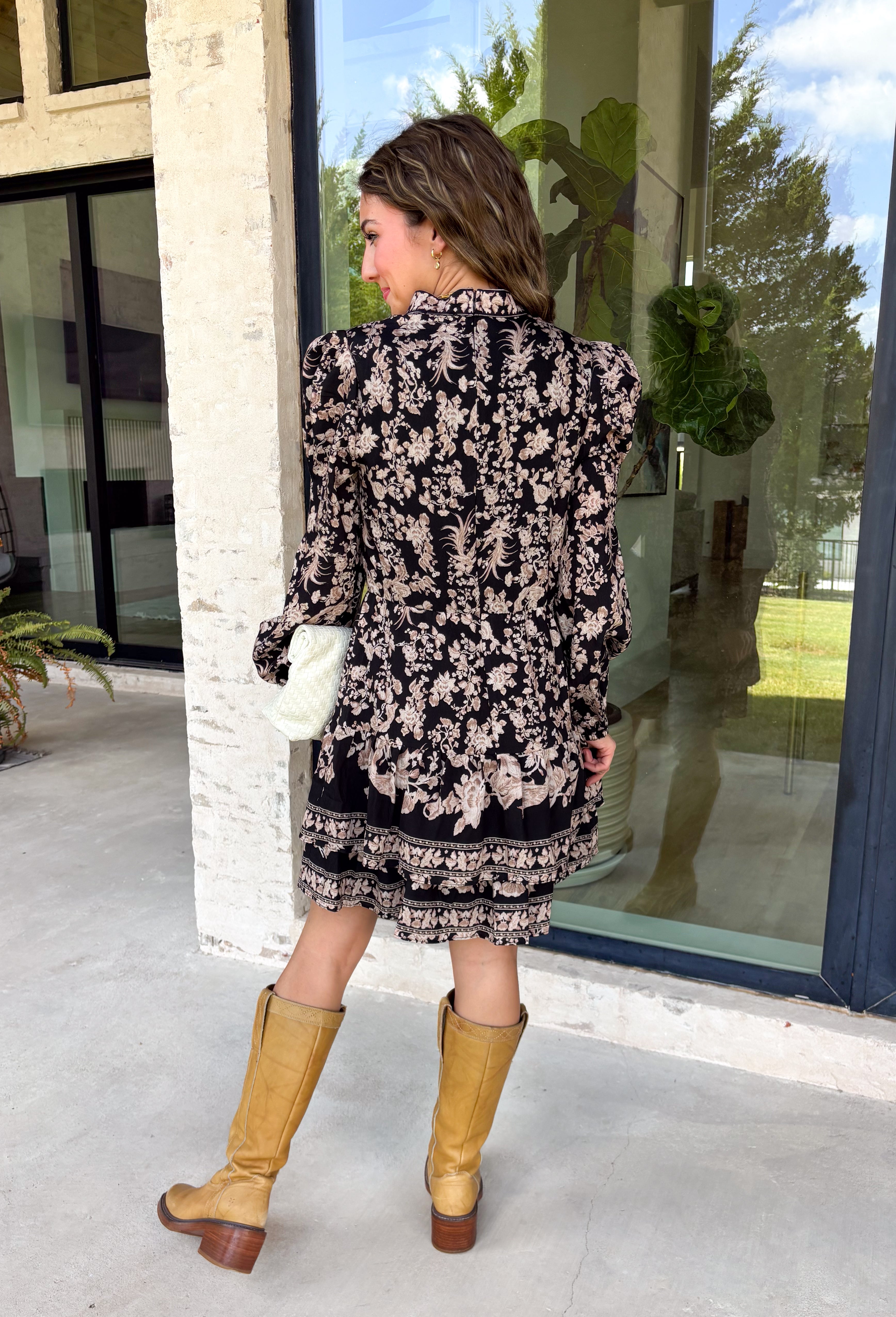 Chic, timeless, and effortlessly feminine, this floral dress is made for every special moment on your fall calendar. Featuring a classic black backdrop with a beautiful tan and off-white floral print, this dress offers a sophisticated look that's easy to wear from day to night. The button-front bodice, long sleeves, and tiered skirt create a flattering silhouette with graceful movement, while the elastic cuffs add a comfortable finishing touch. 