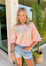 This colorful textured top is the kind of easy, throw-on piece that makes summer dressing fun! With a mix of pink, white, and yellow, it brings a pop of color that feels bright but still easy to style. The waffle texture adds dimension, while the pink trim along the neckline, sleeves, and hem gives it that extra standout detail. Finished with a front pocket for a casual touch, this top is perfect for everyday wear—from errands to coffee runs. Pair it with denim shorts or white jeans and you’re set. 