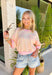 This colorful textured top is the kind of easy, throw-on piece that makes summer dressing fun! With a mix of pink, white, and yellow, it brings a pop of color that feels bright but still easy to style. The waffle texture adds dimension, while the pink trim along the neckline, sleeves, and hem gives it that extra standout detail. Finished with a front pocket for a casual touch, this top is perfect for everyday wear—from errands to coffee runs. Pair it with denim shorts or white jeans and you’re set. 