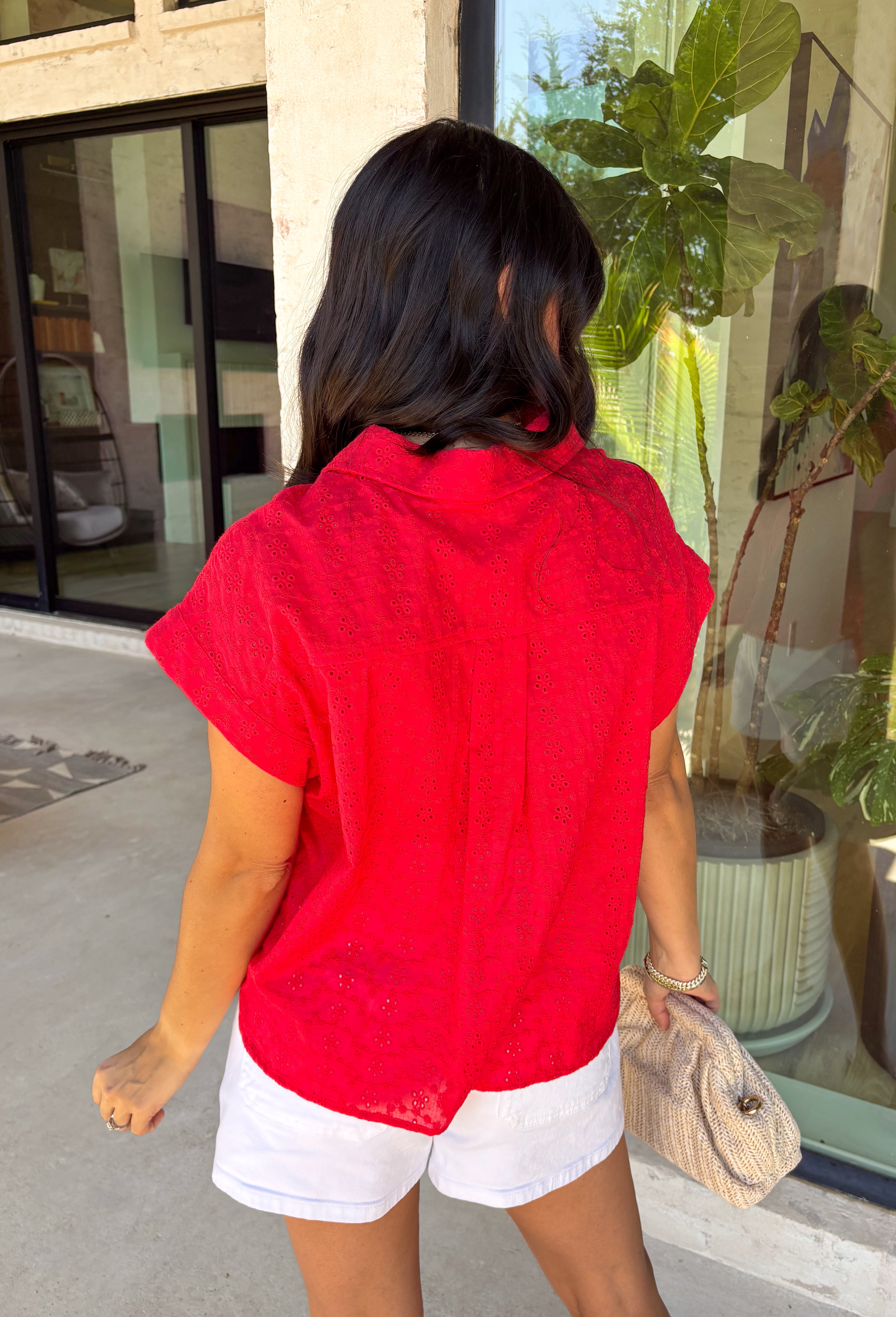 Bold, feminine, and perfect for sunny days! This red short sleeve button down top features beautiful eyelet lace throughout, adding texture and charm to a classic silhouette. The vibrant color makes it an instant standout while the breathable cotton fabric keeps it comfortable and easy to wear. Designed with a collared neckline and full button front, this top blends timeless structure with delicate detail. It’s polished enough to dress up but still relaxed enough for everyday styling.