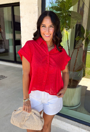 Bold, feminine, and perfect for sunny days! This red short sleeve button down top features beautiful eyelet lace throughout, adding texture and charm to a classic silhouette. The vibrant color makes it an instant standout while the breathable cotton fabric keeps it comfortable and easy to wear. Designed with a collared neckline and full button front, this top blends timeless structure with delicate detail. It’s polished enough to dress up but still relaxed enough for everyday styling.