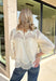 Delicate details and timeless style come together beautifully in this romantic boho-inspired blouse. Crafted from soft cream cotton, this feminine top is adorned with intricate crochet lace throughout, creating a look that's effortlessly elegant while still feeling easy to wear. The high ruffle neckline and scalloped lace accents along the yoke, sleeves, and hem add beautiful texture and vintage-inspired charm, while the keyhole button closure at the back completes the look with a graceful finishing touch. 