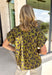 Bring a whimsical touch to your fall wardrobe with this beautifully printed butterfly blouse. Designed in a rich olive green with a striking black butterfly print, this lightweight cotton top offers the perfect balance of playful and polished. The subtle ruffle neckline adds a soft feminine touch, while the button-front detail gives it a timeless feel that's easy to dress up or down.