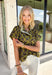 Bring a whimsical touch to your fall wardrobe with this beautifully printed butterfly blouse. Designed in a rich olive green with a striking black butterfly print, this lightweight cotton top offers the perfect balance of playful and polished. The subtle ruffle neckline adds a soft feminine touch, while the button-front detail gives it a timeless feel that's easy to dress up or down.