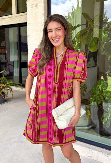 Make a statement this season in this beautifully detailed dress from Entro. Featuring a unique mix of stripes and polka dots in rich shades of plum, burgundy, and olive, this eye-catching dress is full of playful charm with a timeless feel. The flattering v-neckline is accented with decorative front button details, while contrast trim adds an extra touch of personality. 