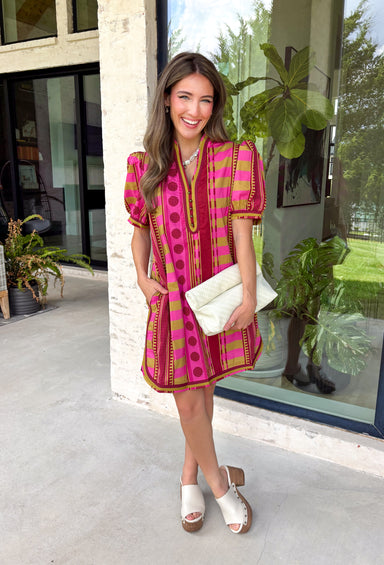 Make a statement this season in this beautifully detailed dress from Entro. Featuring a unique mix of stripes and polka dots in rich shades of plum, burgundy, and olive, this eye-catching dress is full of playful charm with a timeless feel. The flattering v-neckline is accented with decorative front button details, while contrast trim adds an extra touch of personality. 
