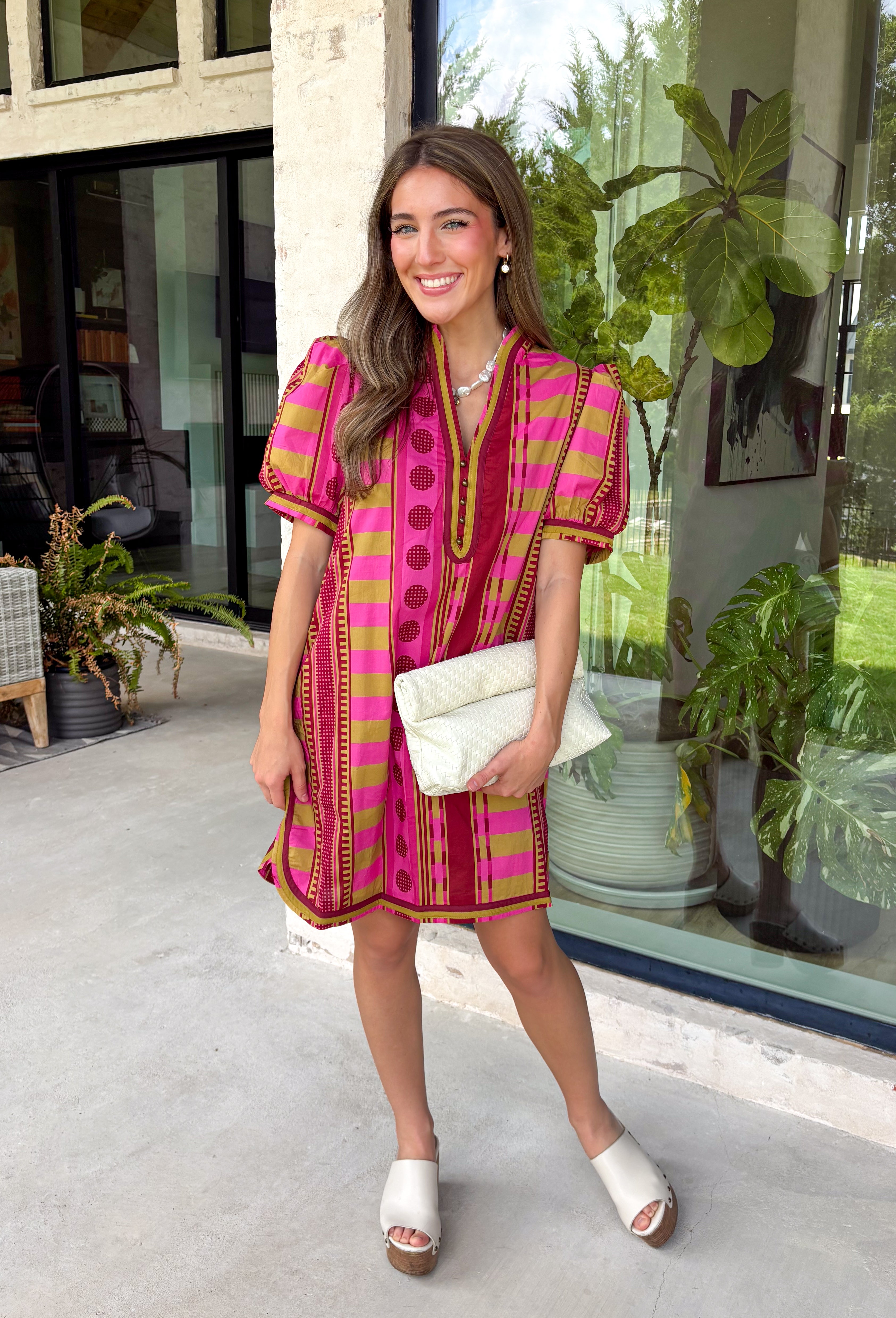Make a statement this season in this beautifully detailed dress from Entro. Featuring a unique mix of stripes and polka dots in rich shades of plum, burgundy, and olive, this eye-catching dress is full of playful charm with a timeless feel. The flattering v-neckline is accented with decorative front button details, while contrast trim adds an extra touch of personality. 