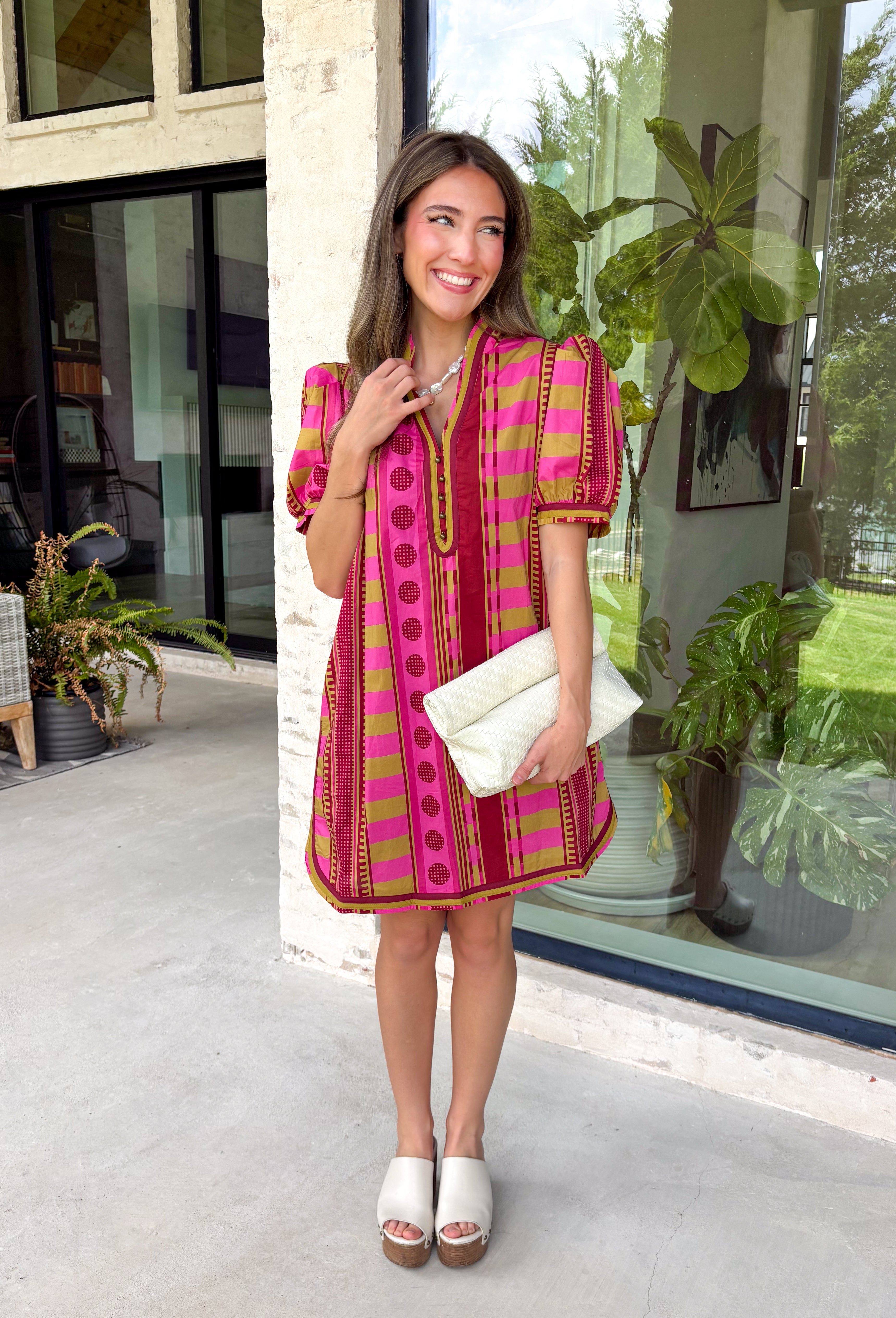 Make a statement this season in this beautifully detailed dress from Entro. Featuring a unique mix of stripes and polka dots in rich shades of plum, burgundy, and olive, this eye-catching dress is full of playful charm with a timeless feel. The flattering v-neckline is accented with decorative front button details, while contrast trim adds an extra touch of personality. 