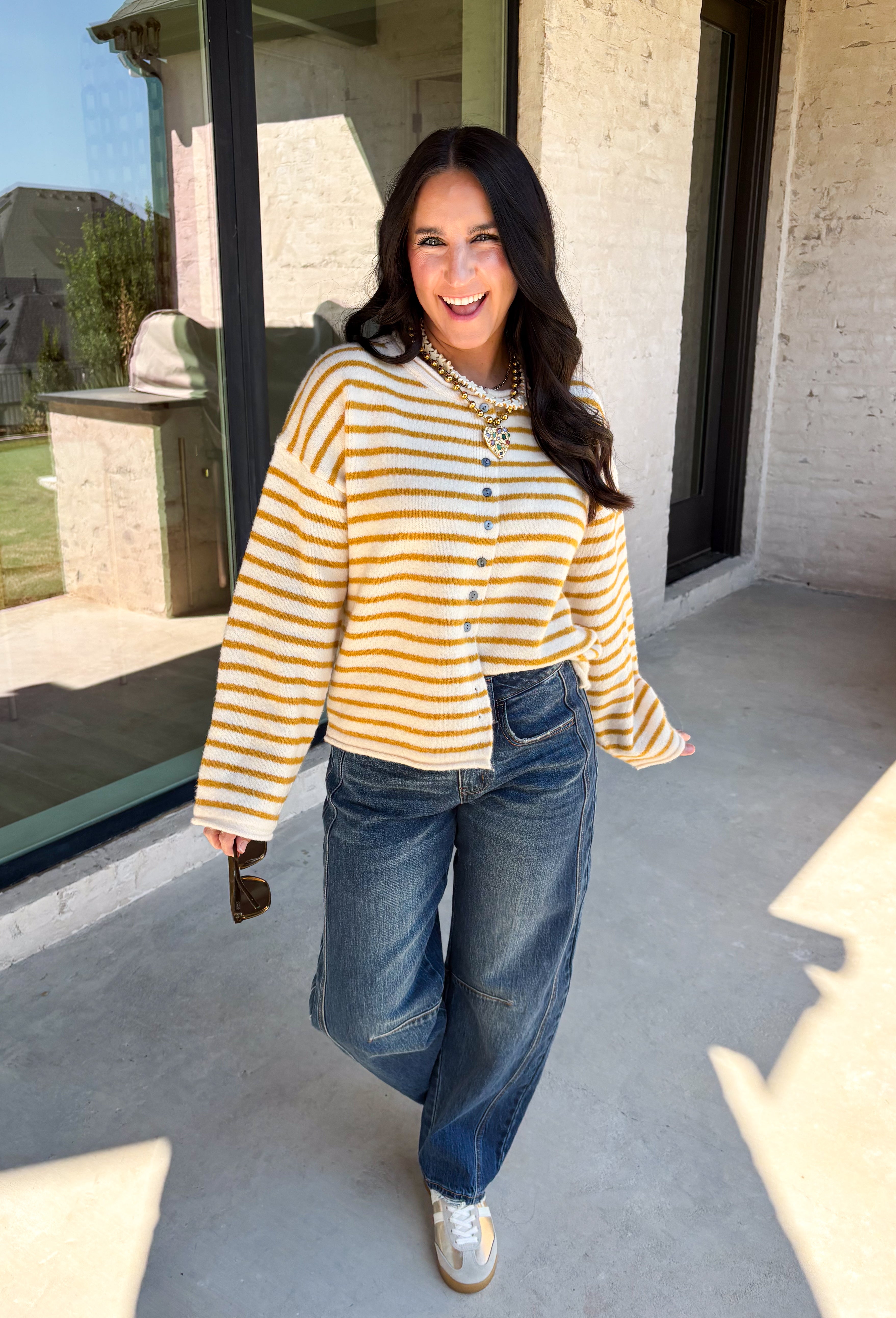 Nothing completes a fall outfit quite like a cozy cardigan. This off white button down cardigan features warm mustard stripes that bring the perfect touch of autumn charm to your wardrobe. The timeless button front makes it easy to wear open or closed, giving you endless styling possibilities throughout the season. Whether you're heading to the office, enjoying a coffee date, or spending the weekend at the pumpkin patch, this soft knit cardigan is one you'll be reaching for again and again.