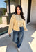 Nothing completes a fall outfit quite like a cozy cardigan. This off white button down cardigan features warm mustard stripes that bring the perfect touch of autumn charm to your wardrobe. The timeless button front makes it easy to wear open or closed, giving you endless styling possibilities throughout the season. Whether you're heading to the office, enjoying a coffee date, or spending the weekend at the pumpkin patch, this soft knit cardigan is one you'll be reaching for again and again.