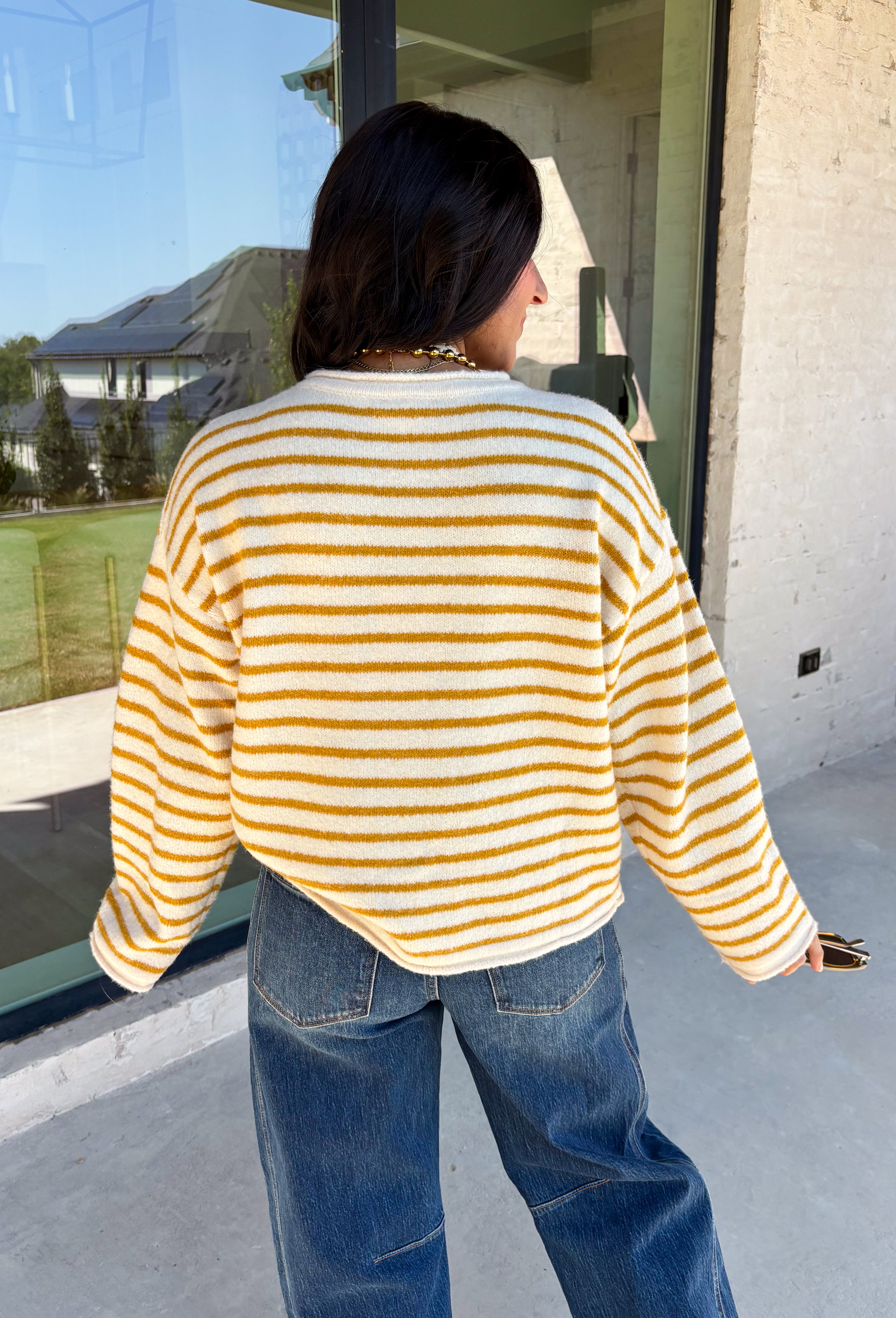 Nothing completes a fall outfit quite like a cozy cardigan. This off white button down cardigan features warm mustard stripes that bring the perfect touch of autumn charm to your wardrobe. The timeless button front makes it easy to wear open or closed, giving you endless styling possibilities throughout the season. Whether you're heading to the office, enjoying a coffee date, or spending the weekend at the pumpkin patch, this soft knit cardigan is one you'll be reaching for again and again.