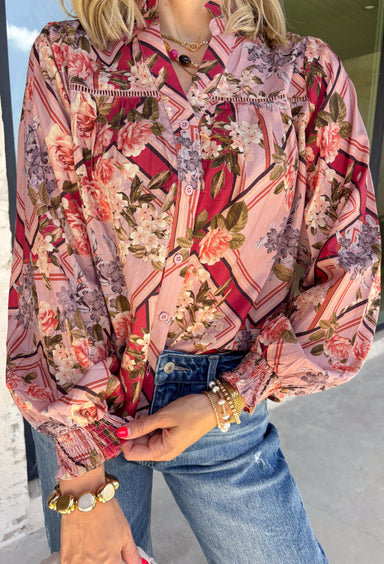 Bring beautiful fall florals into your everyday wardrobe with this effortlessly feminine blouse from Fate. Designed in a soft mauve hue with a floral print in shades of magenta, olive, black, and gray, this timeless top is full of charming details. The button-front design is complemented by a subtle ruffle neckline, while delicate caging detail adds beautiful texture and dimension. 