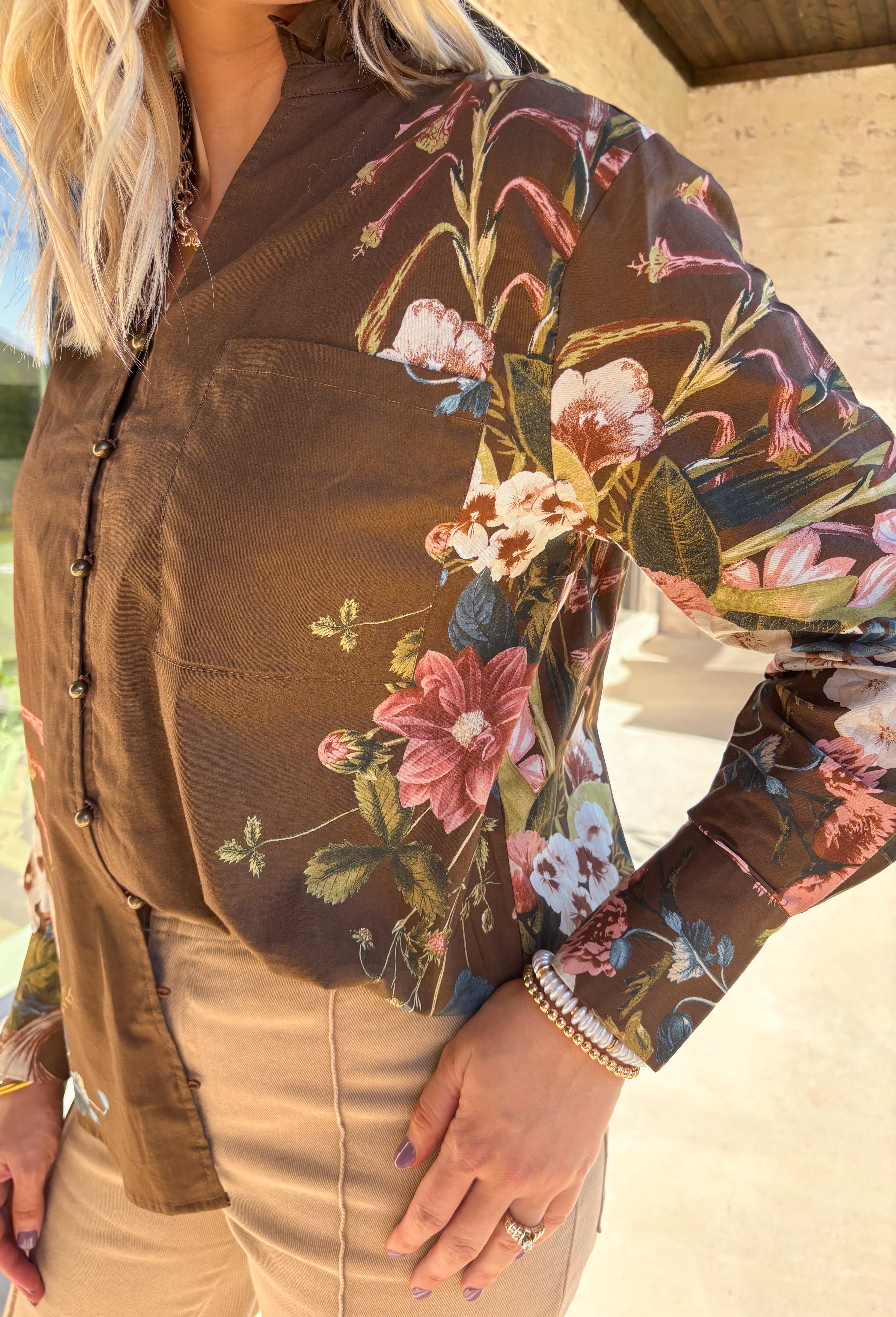 Bring effortless charm to your fall wardrobe with this brown long sleeve top. Designed with floral accent sleeves for a playful pop, it features a ruffle-trimmed v-neckline and button-down front that add a touch of femininity. Made with a soft cotton blend and a hint of stretch, it’s comfortable enough for all-day wear yet stylish enough to dress up or down.