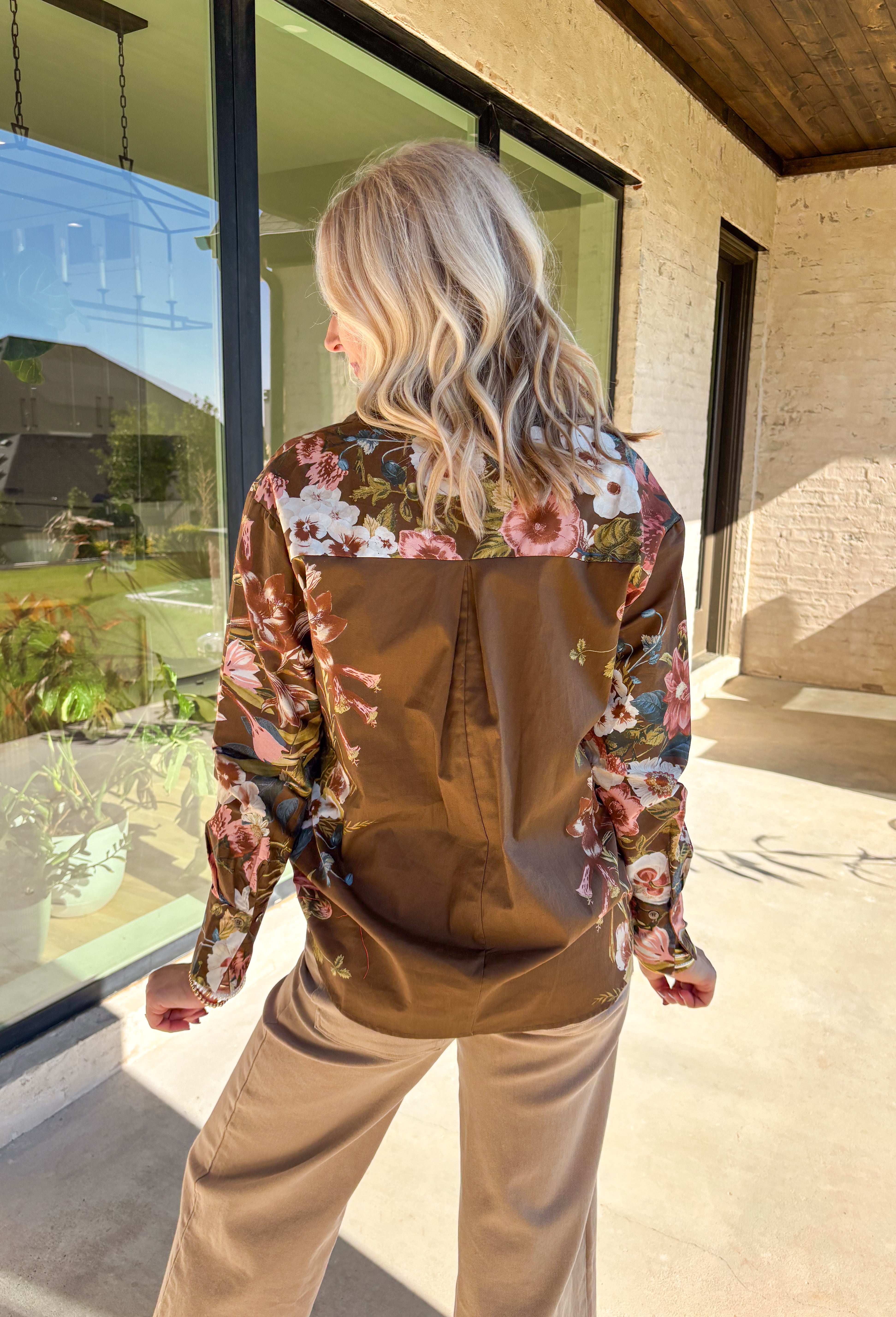 Bring effortless charm to your fall wardrobe with this brown long sleeve top. Designed with floral accent sleeves for a playful pop, it features a ruffle-trimmed v-neckline and button-down front that add a touch of femininity. Made with a soft cotton blend and a hint of stretch, it’s comfortable enough for all-day wear yet stylish enough to dress up or down.