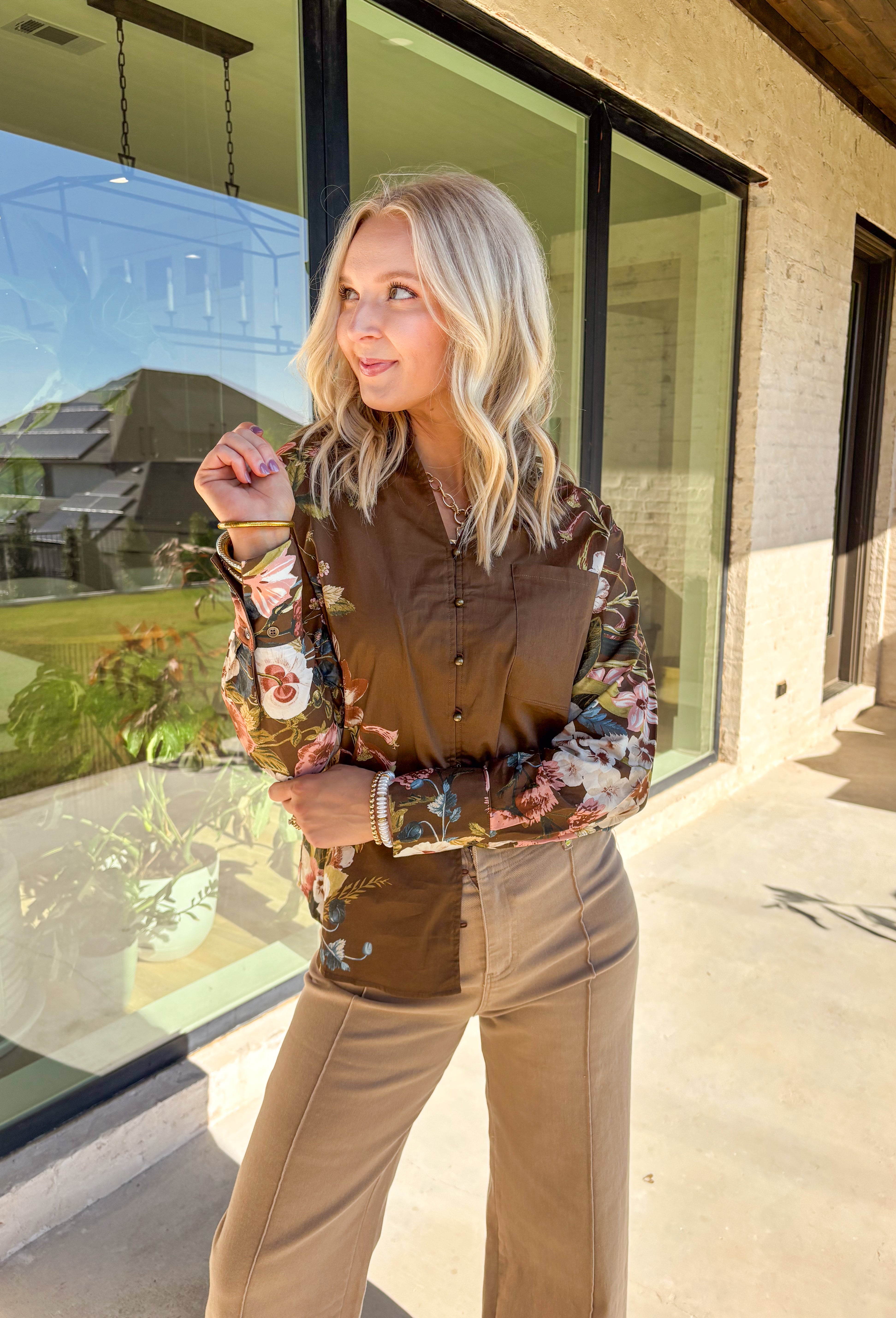 Bring effortless charm to your fall wardrobe with this brown long sleeve top. Designed with floral accent sleeves for a playful pop, it features a ruffle-trimmed v-neckline and button-down front that add a touch of femininity. Made with a soft cotton blend and a hint of stretch, it’s comfortable enough for all-day wear yet stylish enough to dress up or down.