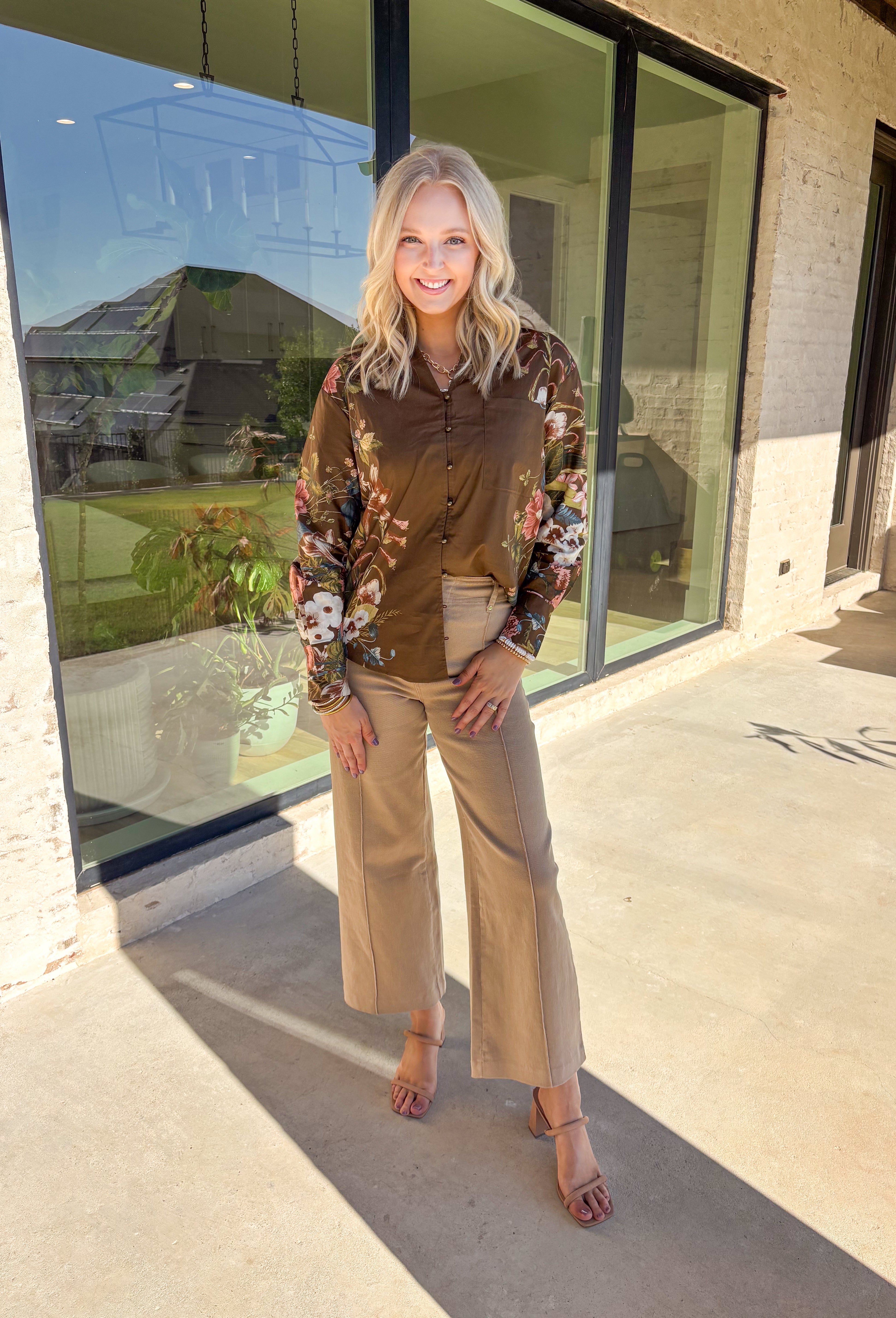 Bring effortless charm to your fall wardrobe with this brown long sleeve top. Designed with floral accent sleeves for a playful pop, it features a ruffle-trimmed v-neckline and button-down front that add a touch of femininity. Made with a soft cotton blend and a hint of stretch, it’s comfortable enough for all-day wear yet stylish enough to dress up or down.