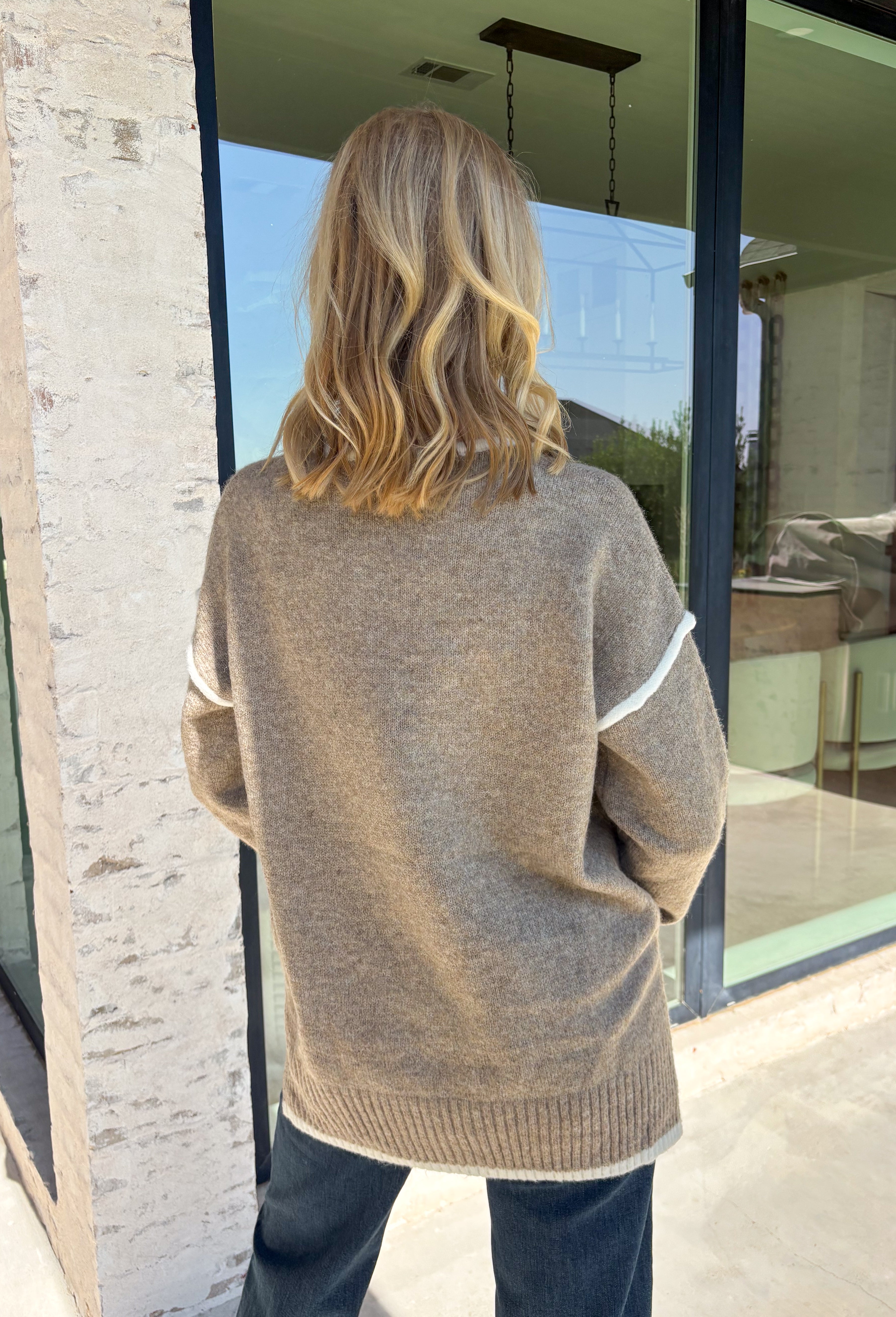 Cozy season calls for an easy sweater you can throw on and instantly feel ready for the day. This light mocha knit sweater from Mable features cream trim throughout, giving the warm neutral color a fresh contrast that stands out without being too bold. The oversized fit creates that relaxed, cozy feel we love for crisp mornings, coffee runs, and laid-back weekends. 