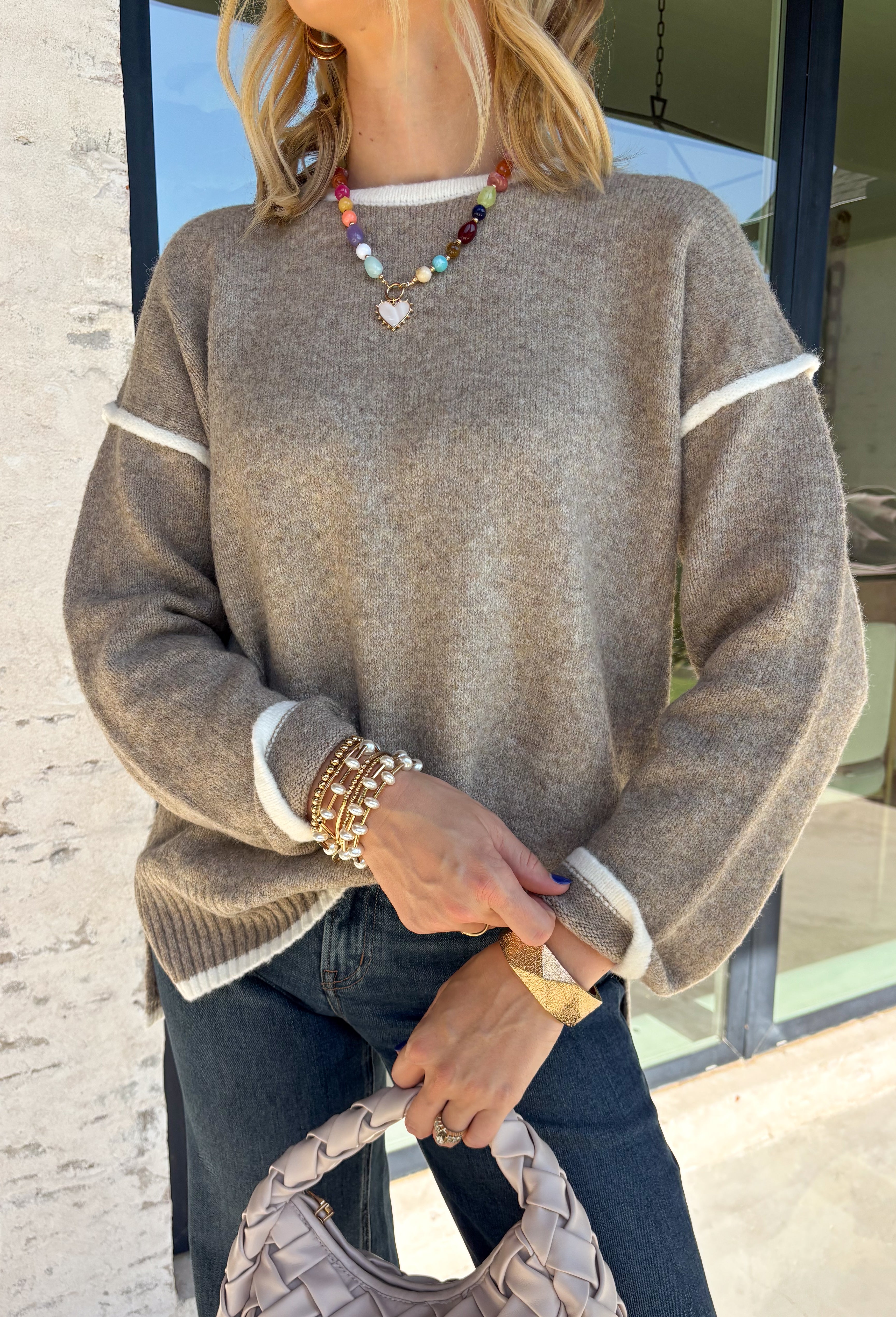 Cozy season calls for an easy sweater you can throw on and instantly feel ready for the day. This light mocha knit sweater from Mable features cream trim throughout, giving the warm neutral color a fresh contrast that stands out without being too bold. The oversized fit creates that relaxed, cozy feel we love for crisp mornings, coffee runs, and laid-back weekends. 