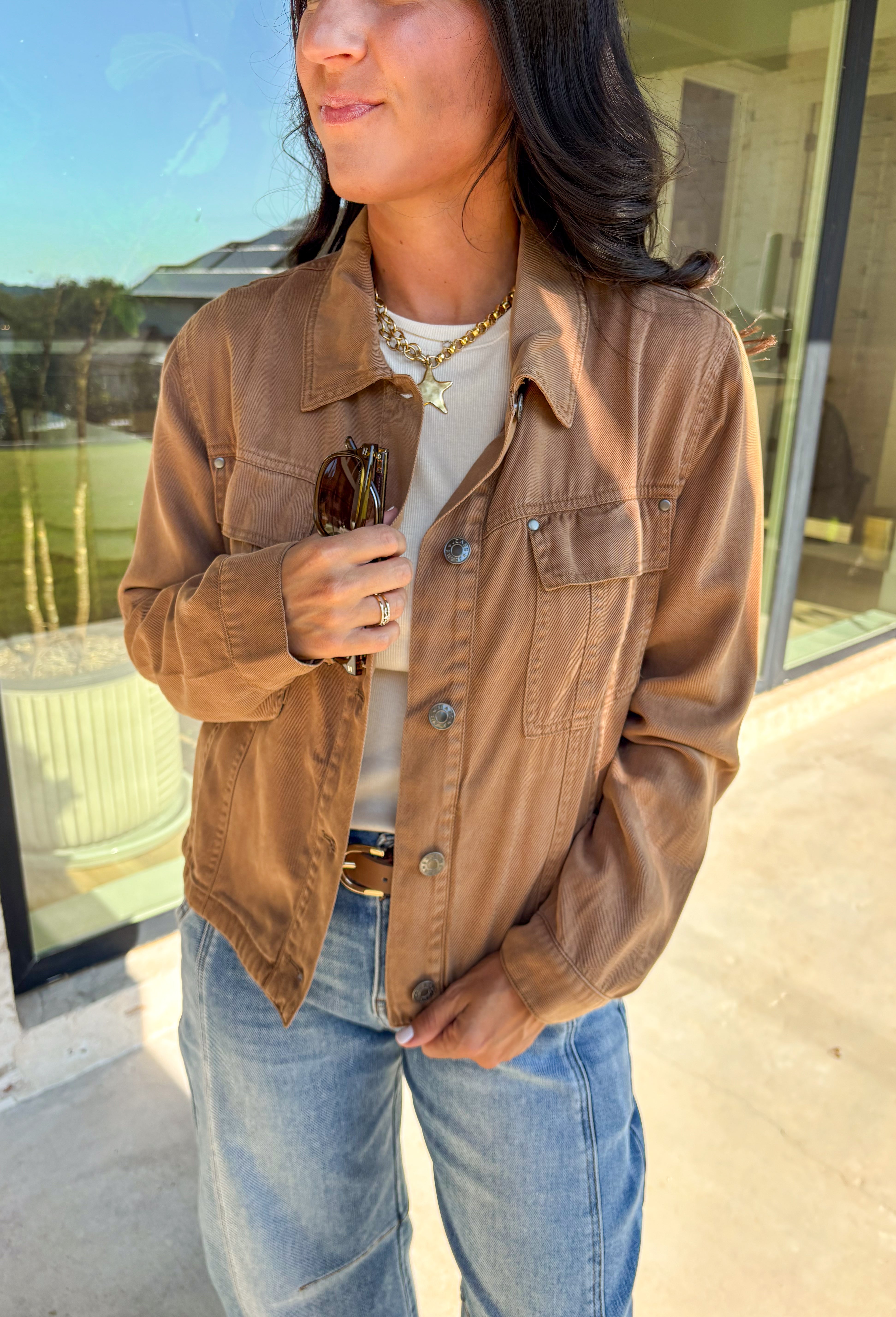 Layering just got easier with this brown lightweight jacket. Designed with a button-down front and collared neckline, it’s a timeless piece that’s easy to style for the season. Front and side pockets keep it functional, while the tencel-cotton-linen blend gives it a soft, breathable feel. Perfect for throwing over sweaters, tees, or dresses, this jacket is a go-to for those crisp fall days when you want an effortless extra layer.