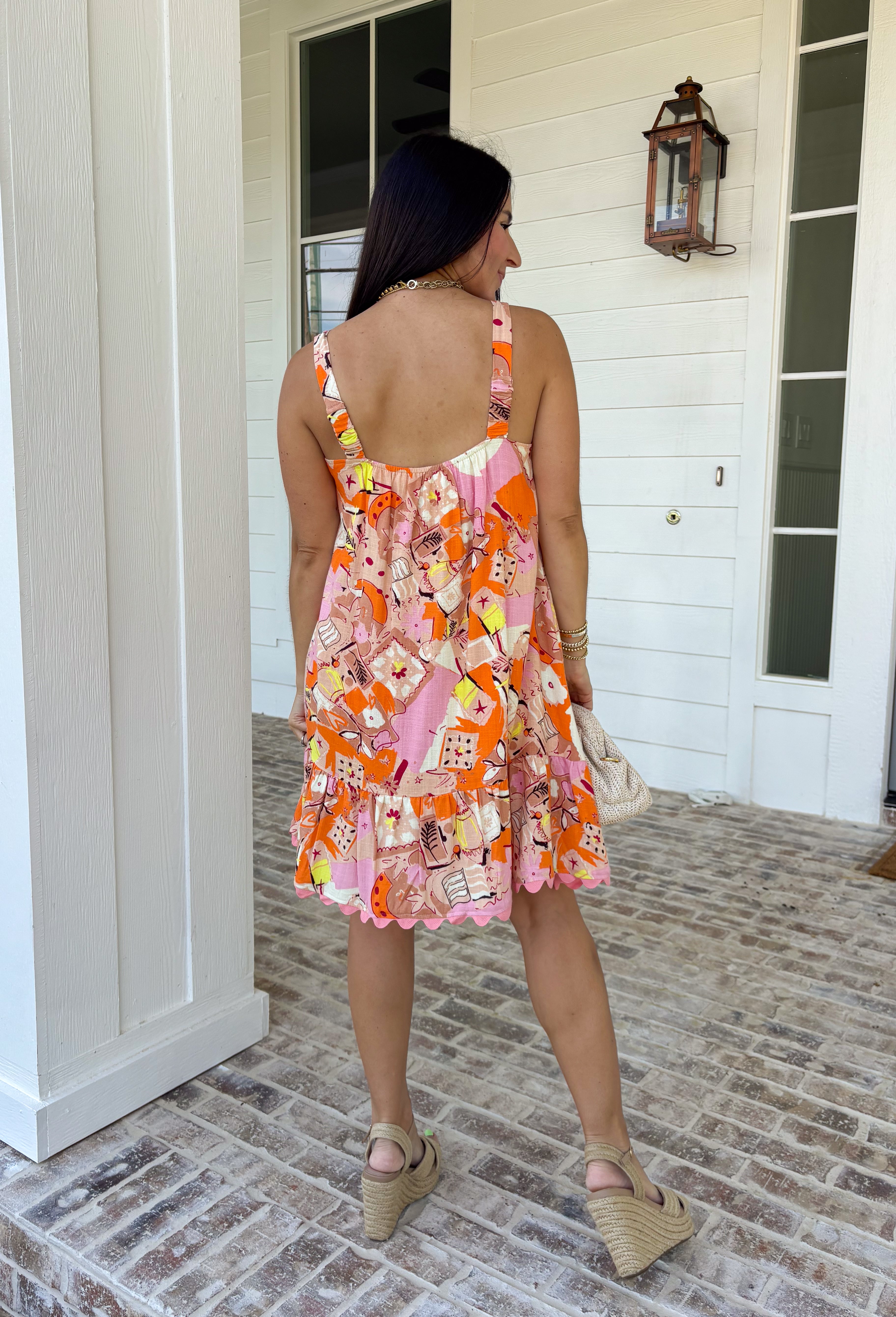 Make an entrance in this bold abstract print dress that was made for sunny days and standout moments. With vibrant shades of orange, pink, tan, black, yellow, and white throughout, this sleeveless beauty feels like wearable art. The orange scallop trim along the neckline and pink scallop trim at the hem add the sweetest contrast, giving it that extra pop of personality. Lightweight and fully lined for easy wear.