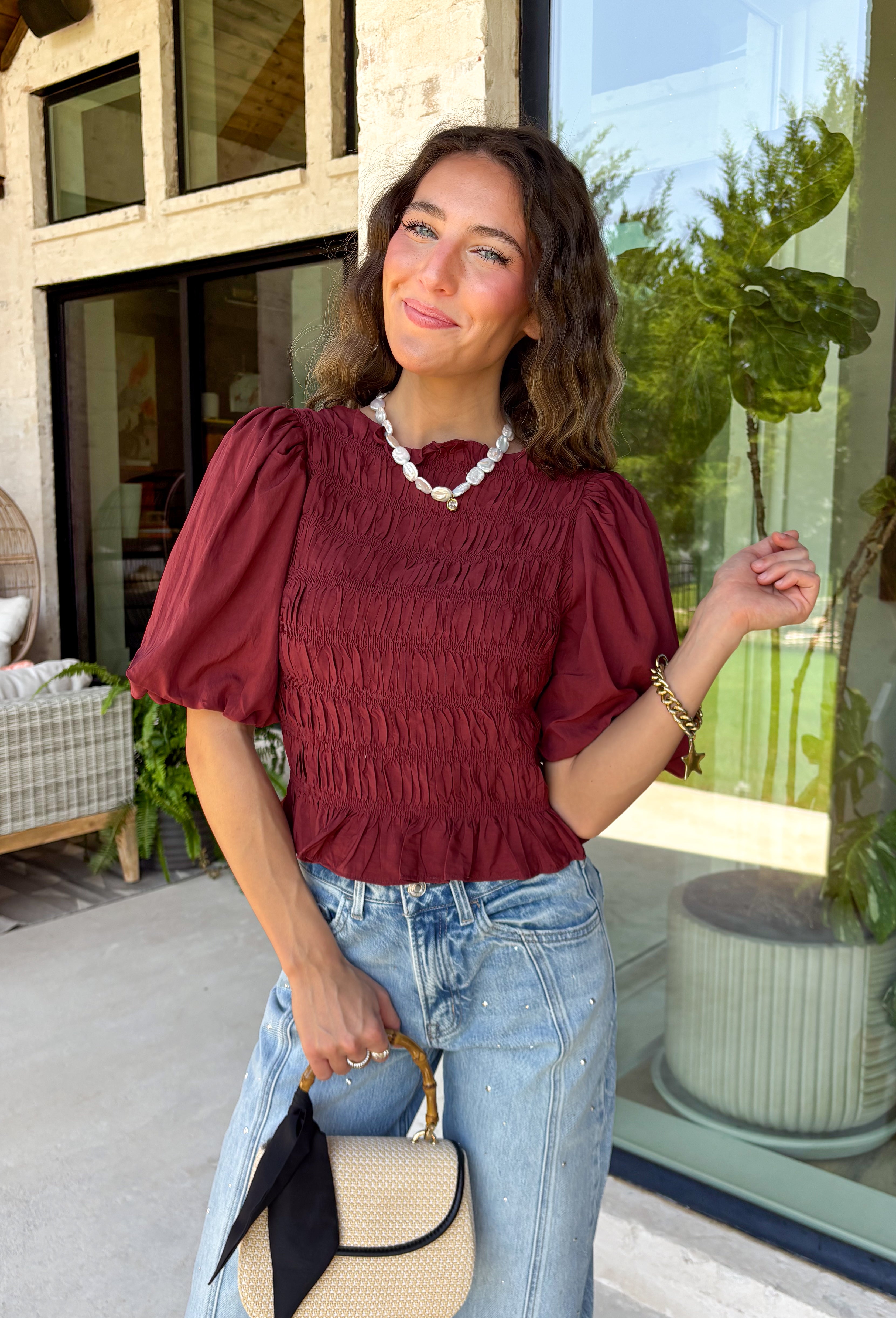 Rich autumn color and feminine details come together beautifully in this brick peplum top. Designed with a flattering smocked bodice, this top offers a comfortable fit while creating a timeless silhouette you'll love. The delicate ruffle neckline and ruffle hem add just the right amount of charm, while the puff sleeves complete the look with a classic fall feel. 