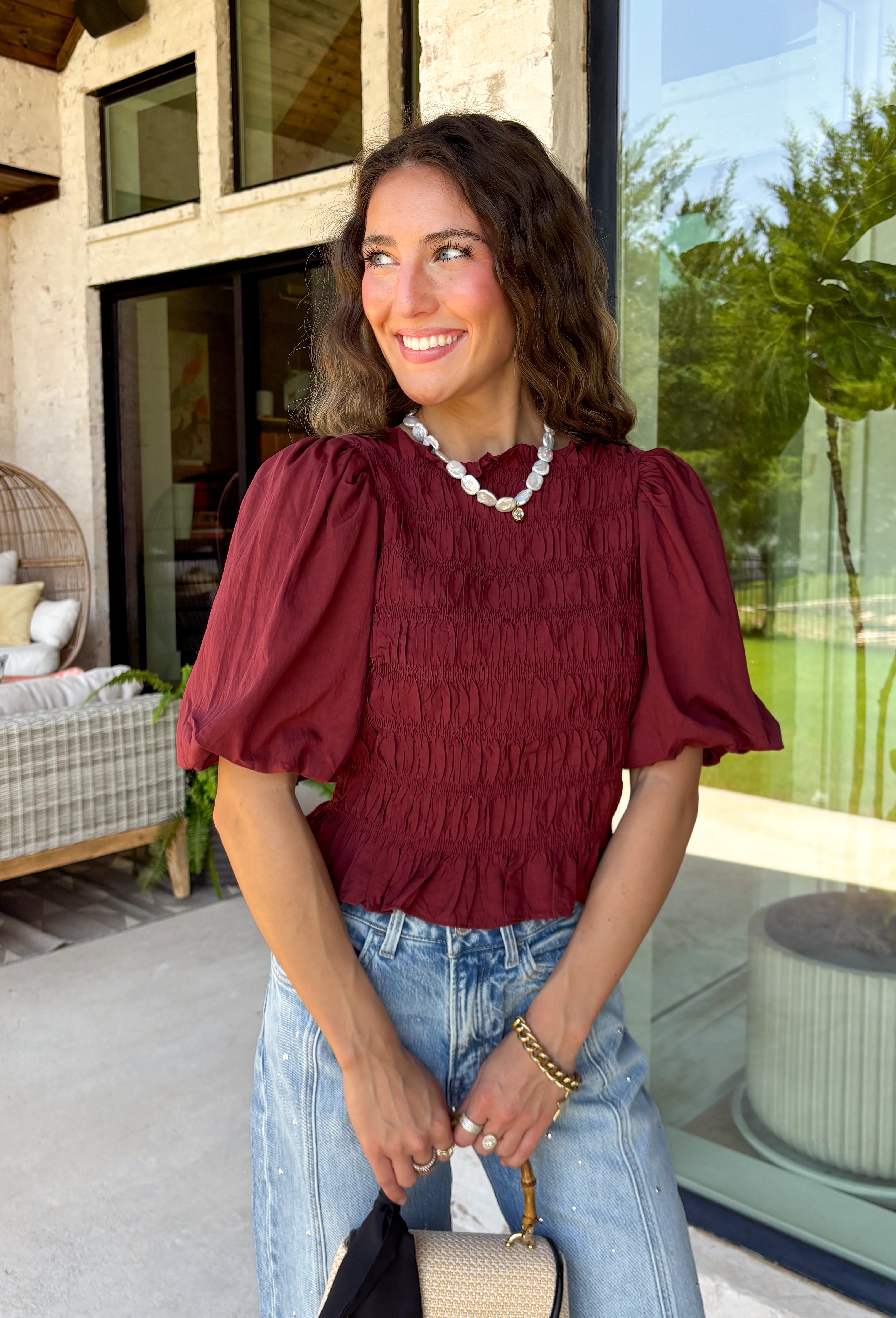 Rich autumn color and feminine details come together beautifully in this brick peplum top. Designed with a flattering smocked bodice, this top offers a comfortable fit while creating a timeless silhouette you'll love. The delicate ruffle neckline and ruffle hem add just the right amount of charm, while the puff sleeves complete the look with a classic fall feel. 