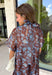 Turn heads at your next special event in this stunning floral maxi dress from Entro. Featuring a rich brown backdrop with a beautiful blue floral print, this elegant dress is designed to make every occasion feel a little more special. The self-tie detail at the back neckline adds a graceful finishing touch, while the flowing maxi silhouette creates effortless movement with every step. 